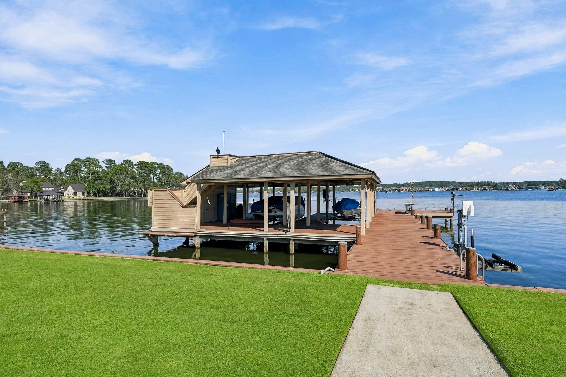 9354 Escondido Drive, Willis, TX 77318 Exceptional waterfront living! This impressive two-story boathouse features two covered boat slips, expansive decking and direct access to the open waters of Lake Conroe.