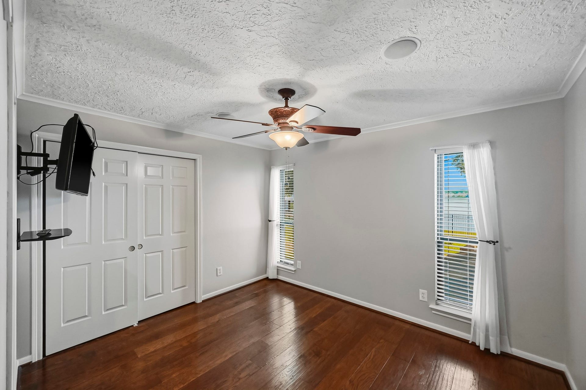 9354 Escondido Drive, Willis, TX 77318 Bedroom #4 is light and bright with wood-look tile flooring, a ceiling fan and windows that welcome natural light overlooking the lake.