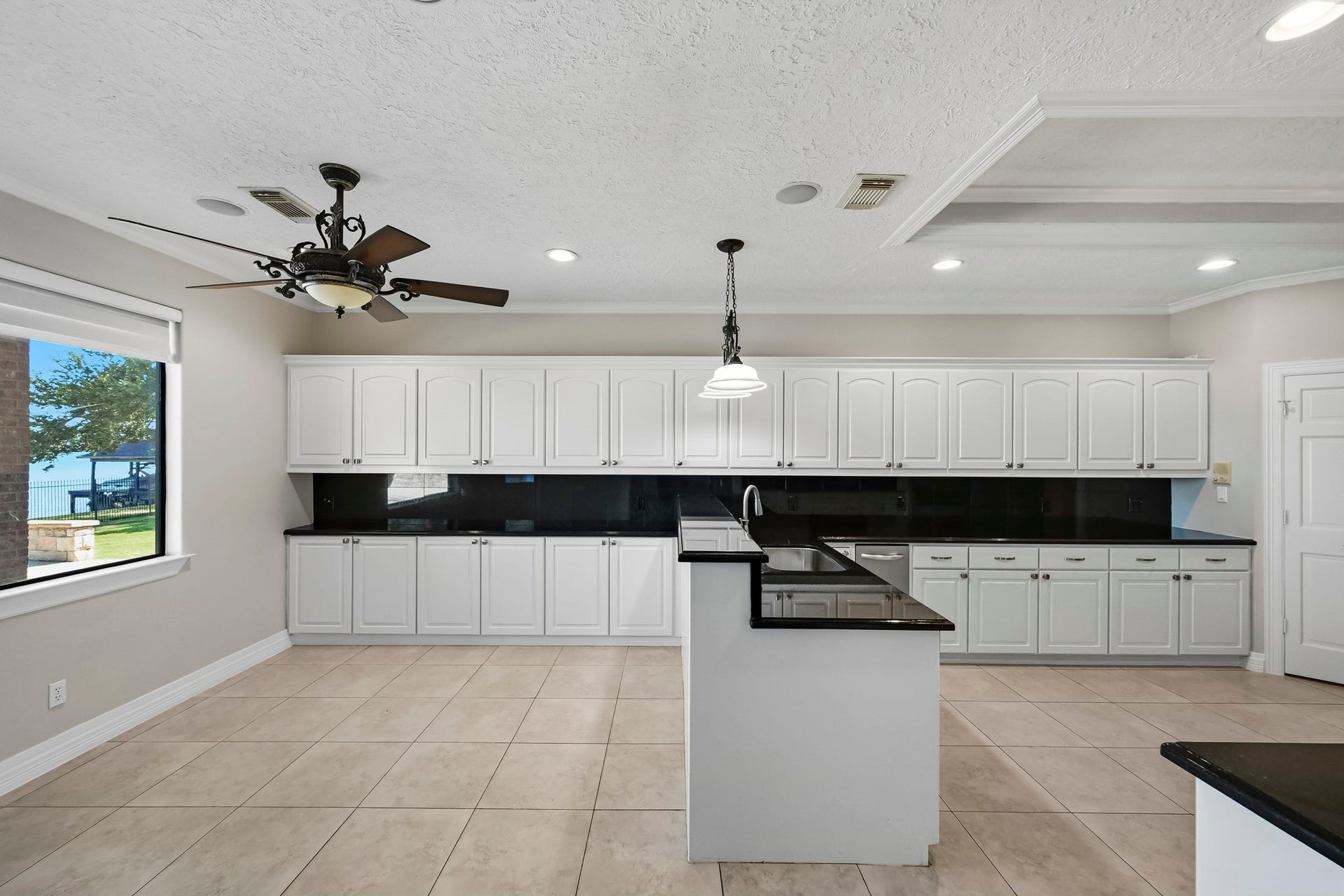 9354 Escondido Drive, Willis, TX 77318 This generously sized kitchen offers extensive white cabinetry, granite countertops, a convenient prep peninsula and plenty of workspace.