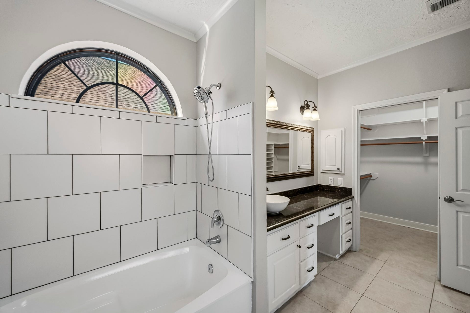 9354 Escondido Drive, Willis, TX 77318 A beautiful arched window adds architectural charm above the soaking tub, while an adjoining walk-in closet provides convenient storage.