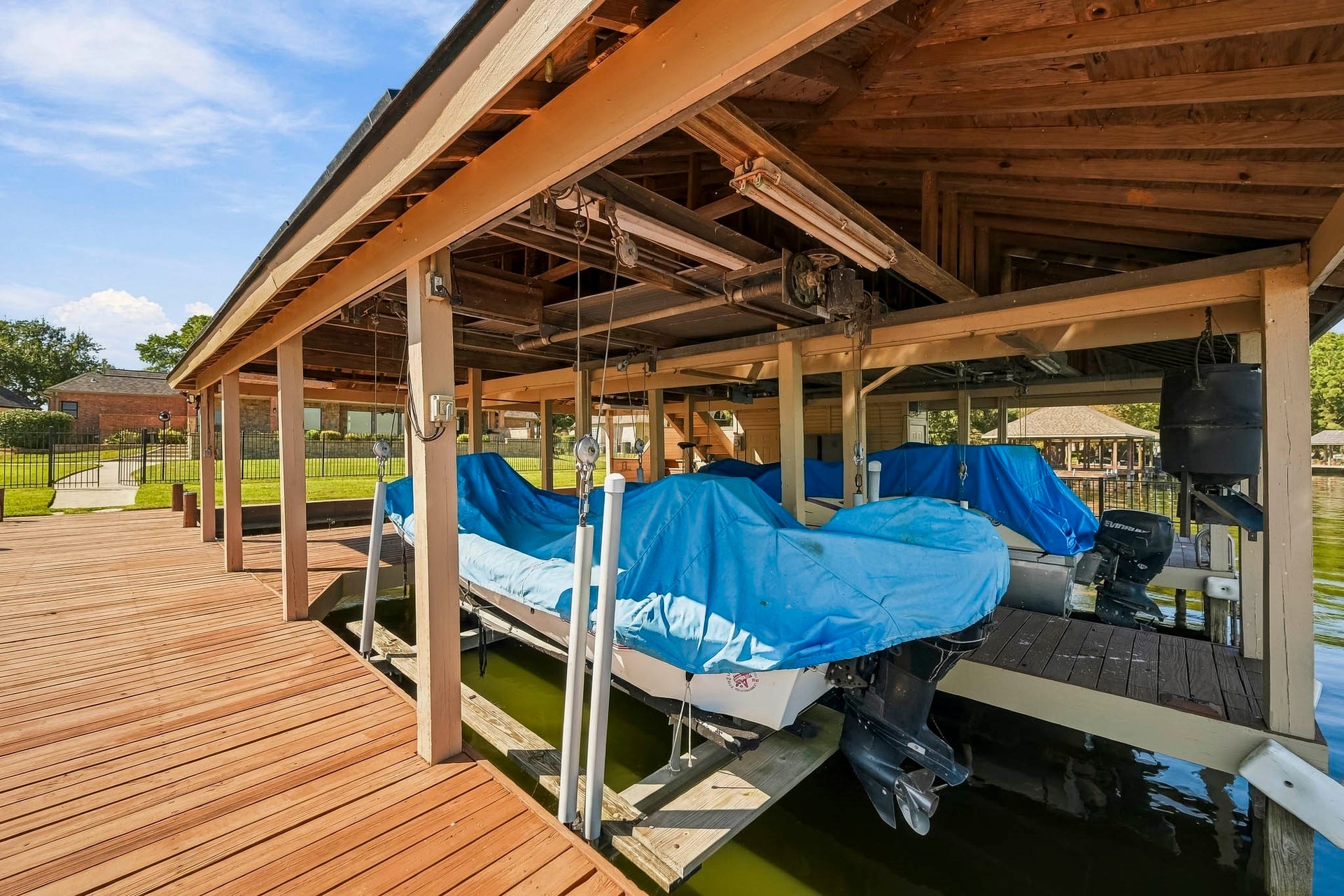 9354 Escondido Drive, Willis, TX 77318 Boating enthusiasts will appreciate TWO covered boat slips with lifts and a spacious wooden dock providing convenient access to the water. Boats not included.
