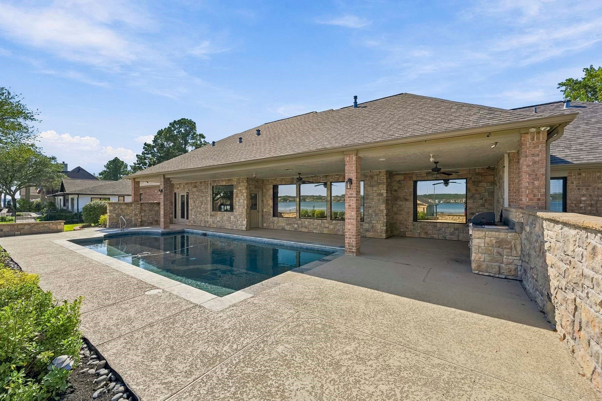 9354 Escondido Drive, Willis, TX 77318 Designed for indoor-outdoor living, the covered patio extends along the home and overlooks the pool, creating an inviting space to gather and relax.