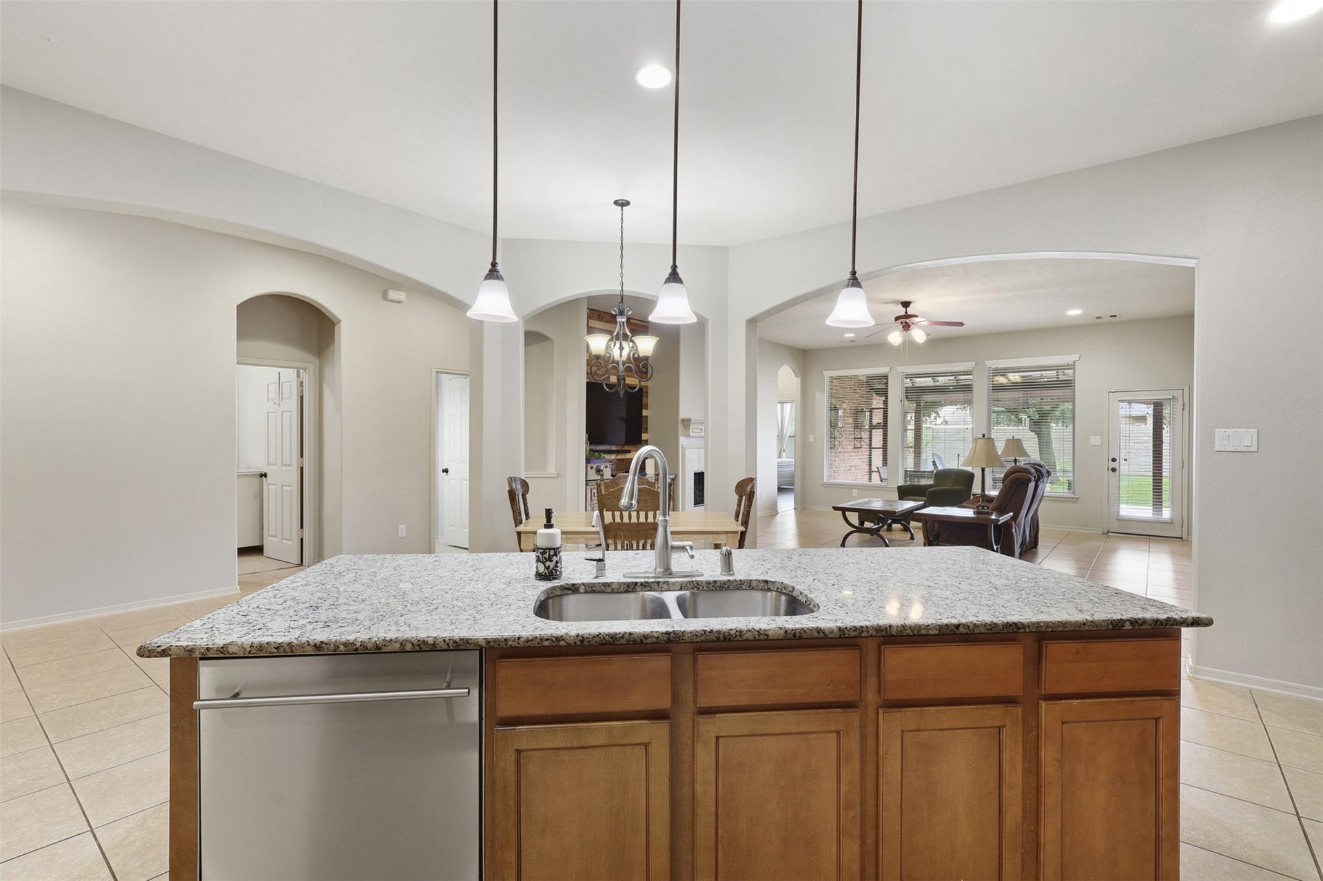 2902 Red Maple Drive, Katy, TX 77494 This angle beautifully showcases the oversized granite island, offering ample prep space, additional seating, & a undermount sink with an upgraded goose-neck faucet. Pendant lighting adds a stylish touch overhead while the open sightlines allow easy interaction throughout.