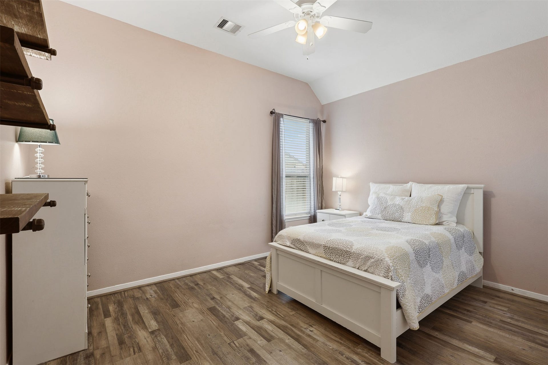 2902 Red Maple Drive, Katy, TX 77494 This spacious secondary bedroom features soaring ceilings, wood-look flooring, and a bright window that fills the room with natural light. The neutral color palette and flexible layout make it ideal for family, guests, or a home office.