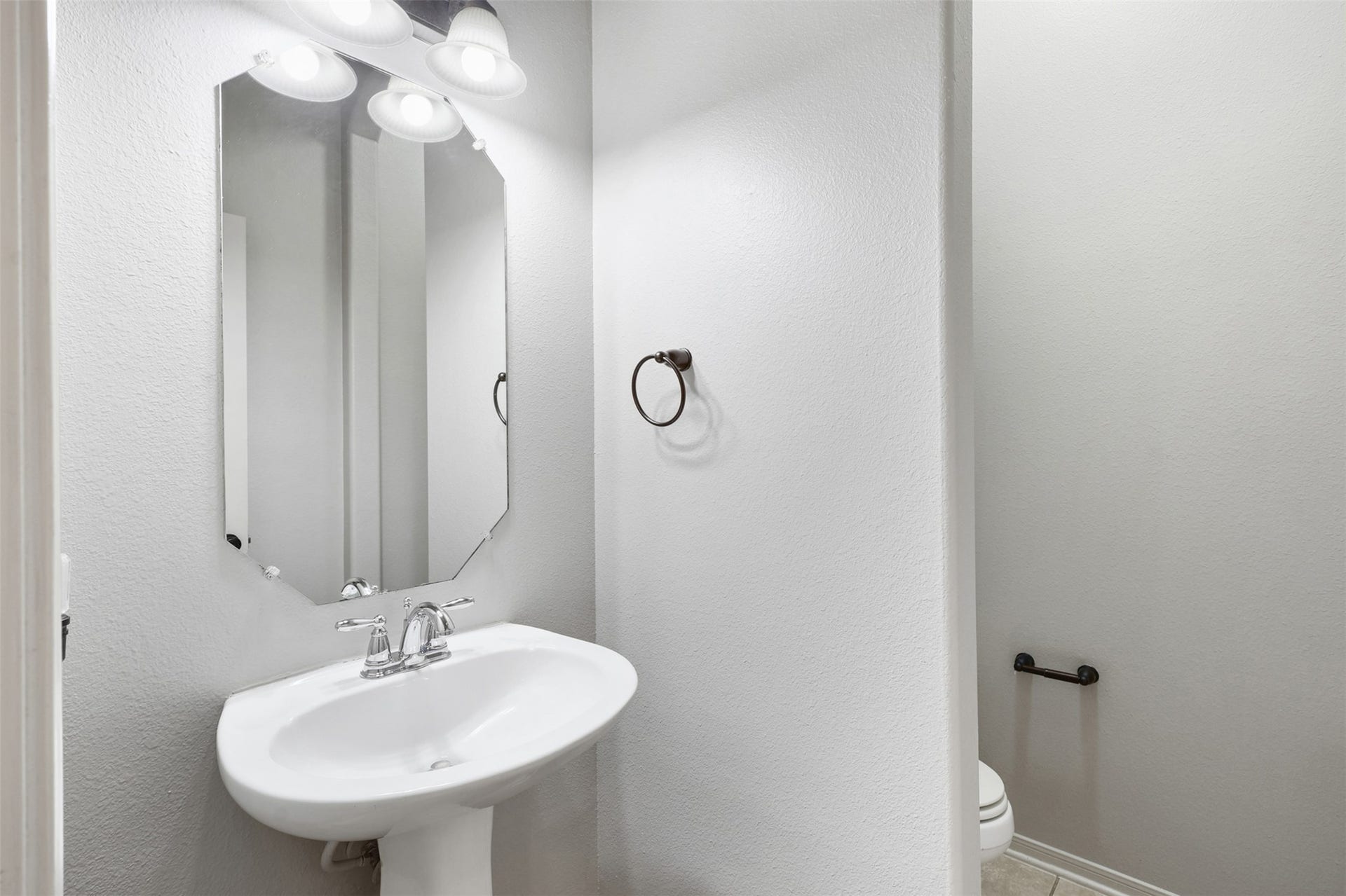 2902 Red Maple Drive, Katy, TX 77494 Perfectly positioned for guests, the powder bathroom features a pedestal sink, updated lighting, and a neutral color palette. Its convenient location near the main living areas makes entertaining effortless.