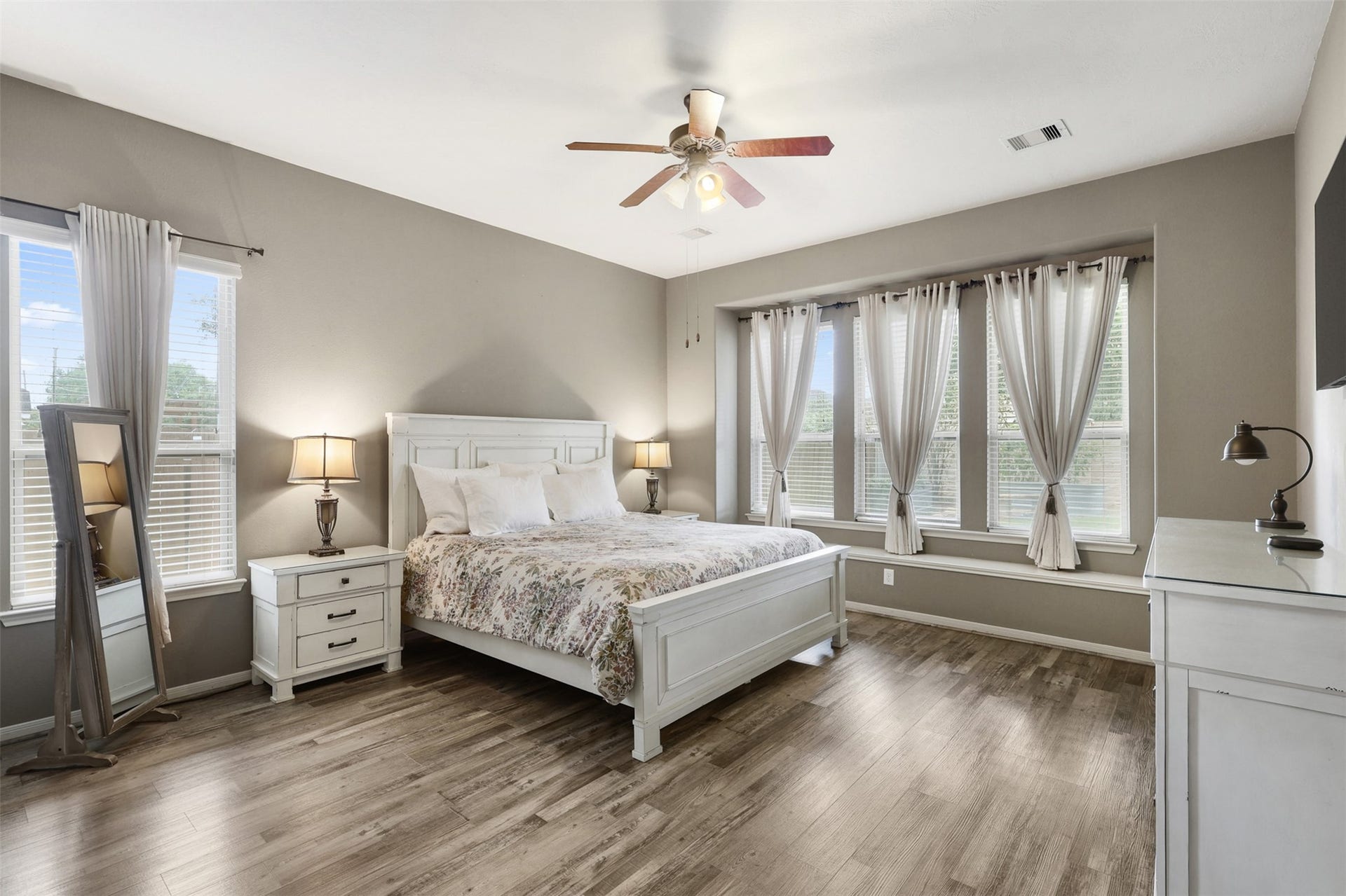 2902 Red Maple Drive, Katy, TX 77494 The spacious primary suite offers a peaceful retreat designed for comfort and relaxation. Beautiful wood-look flooring, soaring ceilings, and soft neutral tones create an inviting atmosphere.