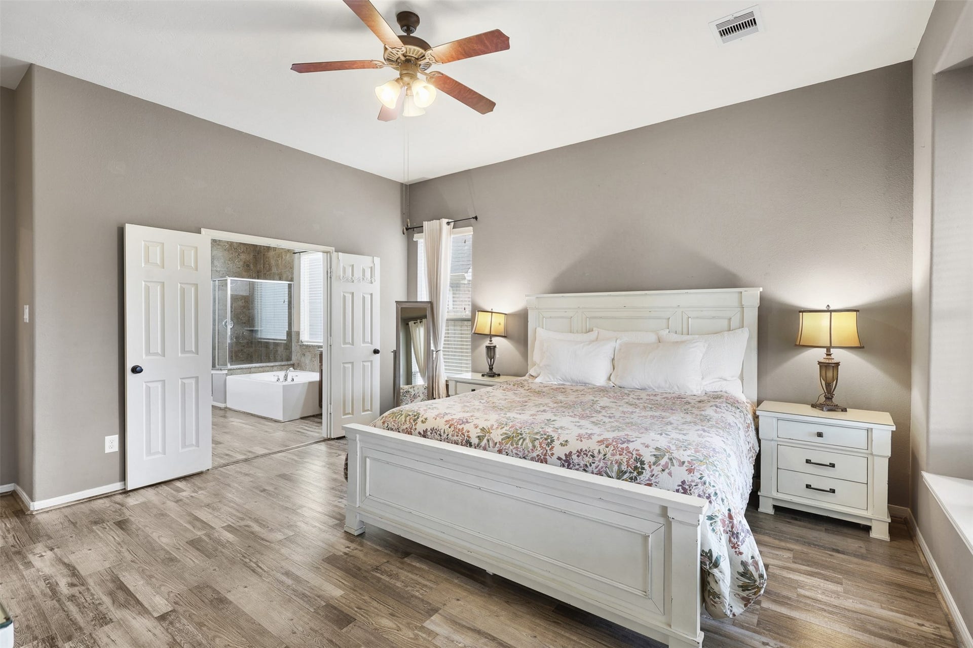 2902 Red Maple Drive, Katy, TX 77494 Another view of the primary retreat highlights the room's impressive scale and thoughtful layout. The high ceiling enhances the sense of space, while large windows frame backyard views and bring warmth and natural light into the space throughout the day.