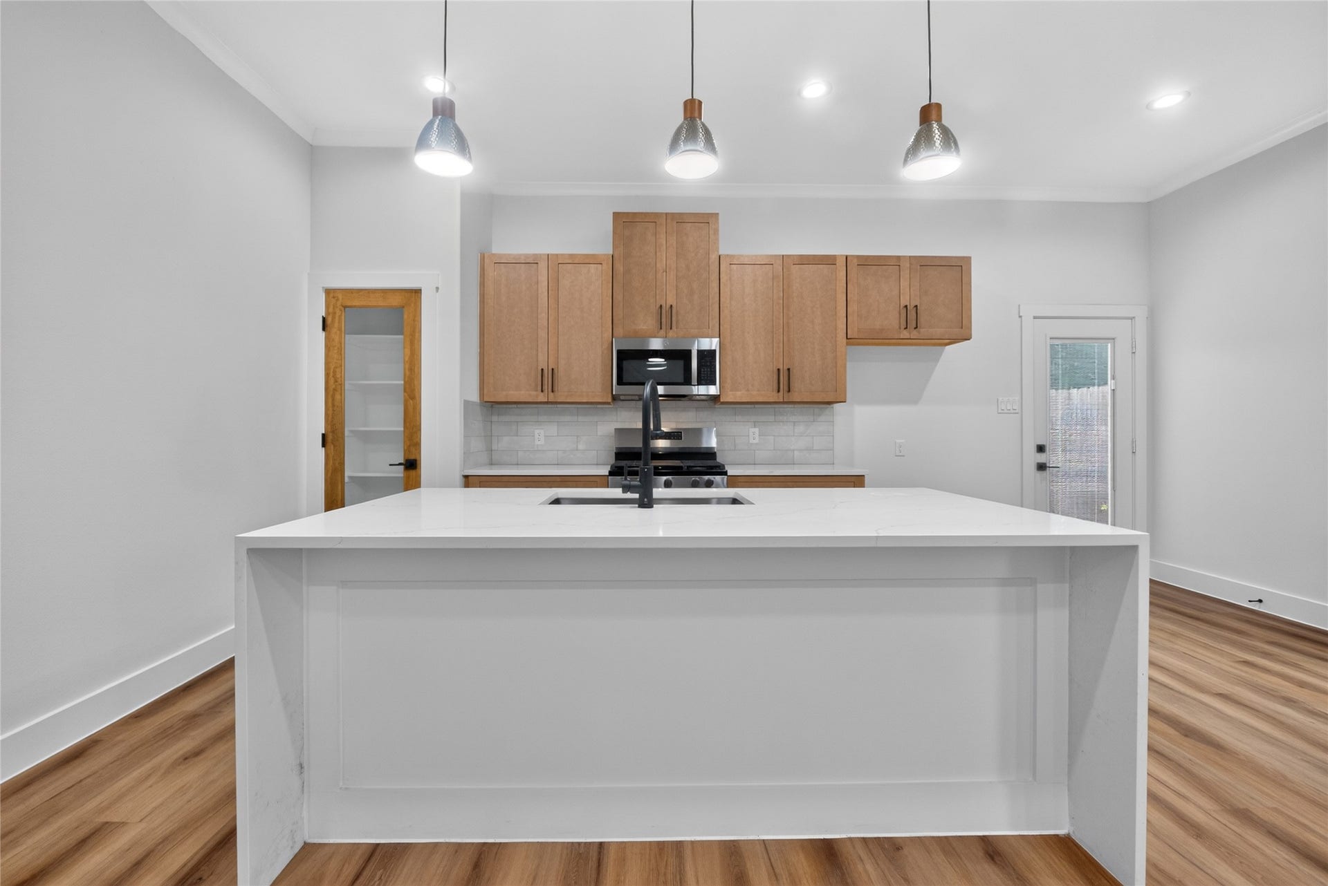 3537 Amos Street, Houston, TX 77021 A refined kitchen anchored by a generous island, sleek stainless-steel appliances, and a spacious pantry for effortless storage--modern and functional. Refrigerator to be installed.