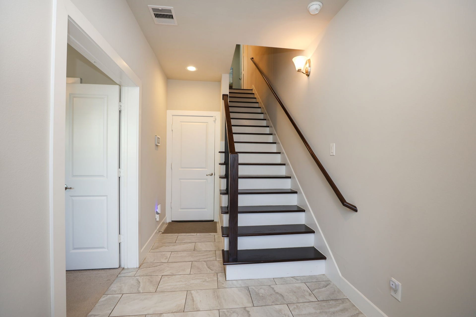 4515 Cornish Street, #A, Houston, TX 77007 View as you enter the home, featuring marble style tile and hardwood floors going up the stairs. Double doors to your left enter the first bedroom/office. Door in center goes to your garage.