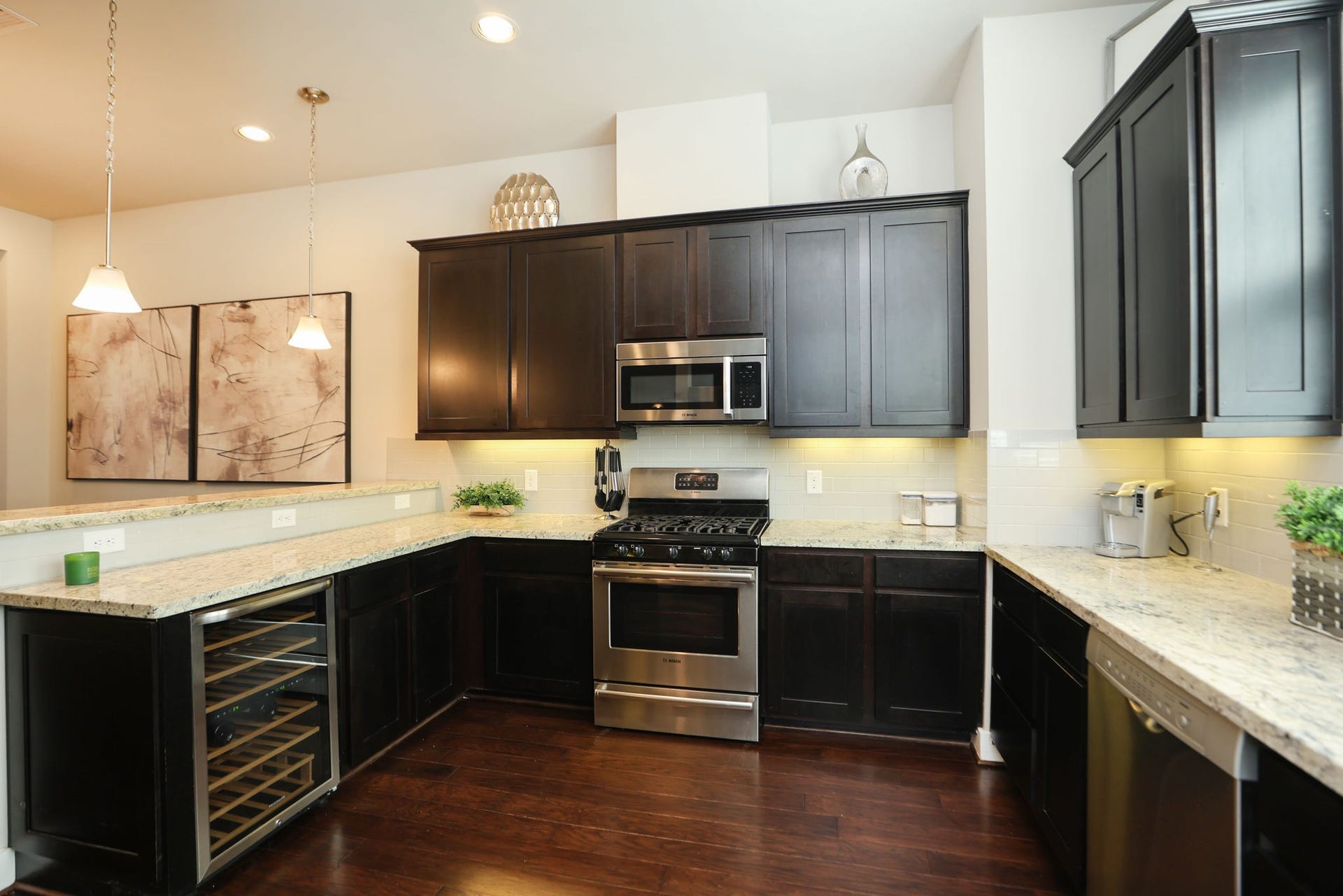 4515 Cornish Street, #A, Houston, TX 77007 Full kitchen with gas range, microwave, wine fridge, pendant lights and beautiful hardwood floors. High ceilings have can inset lights for optional brightness.