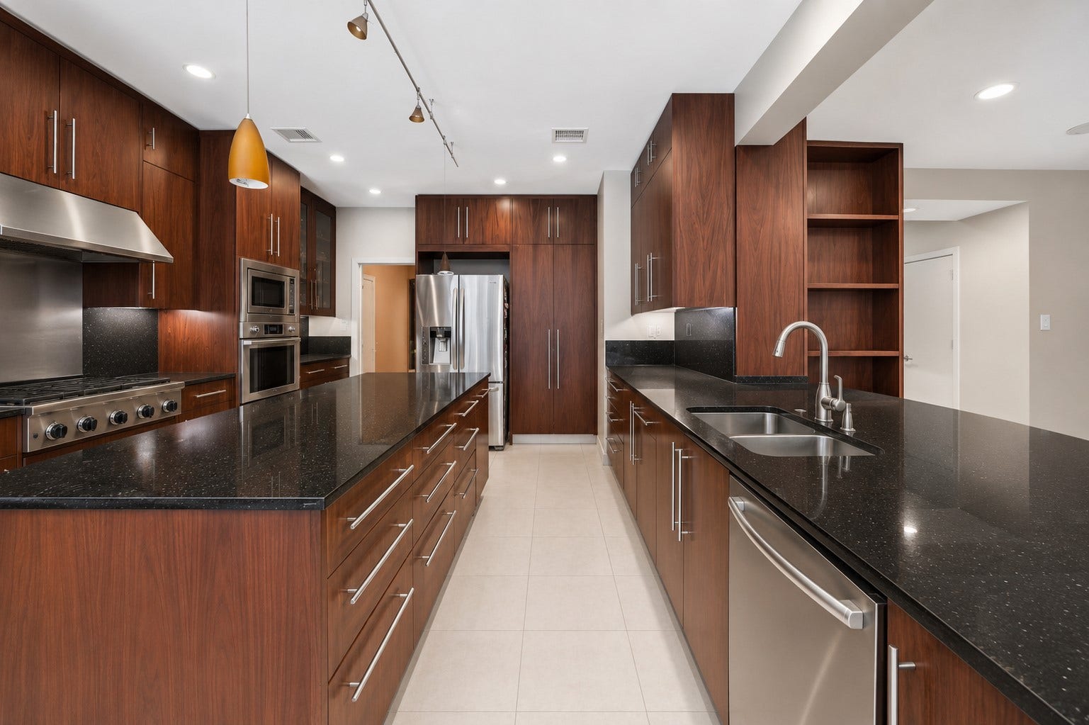 7610 Guinevere Drive, Sugar Land, TX 77479 An under-mount double sink with a gooseneck faucet is integrated seamlessly into the long quartz-topped breakfast bar.