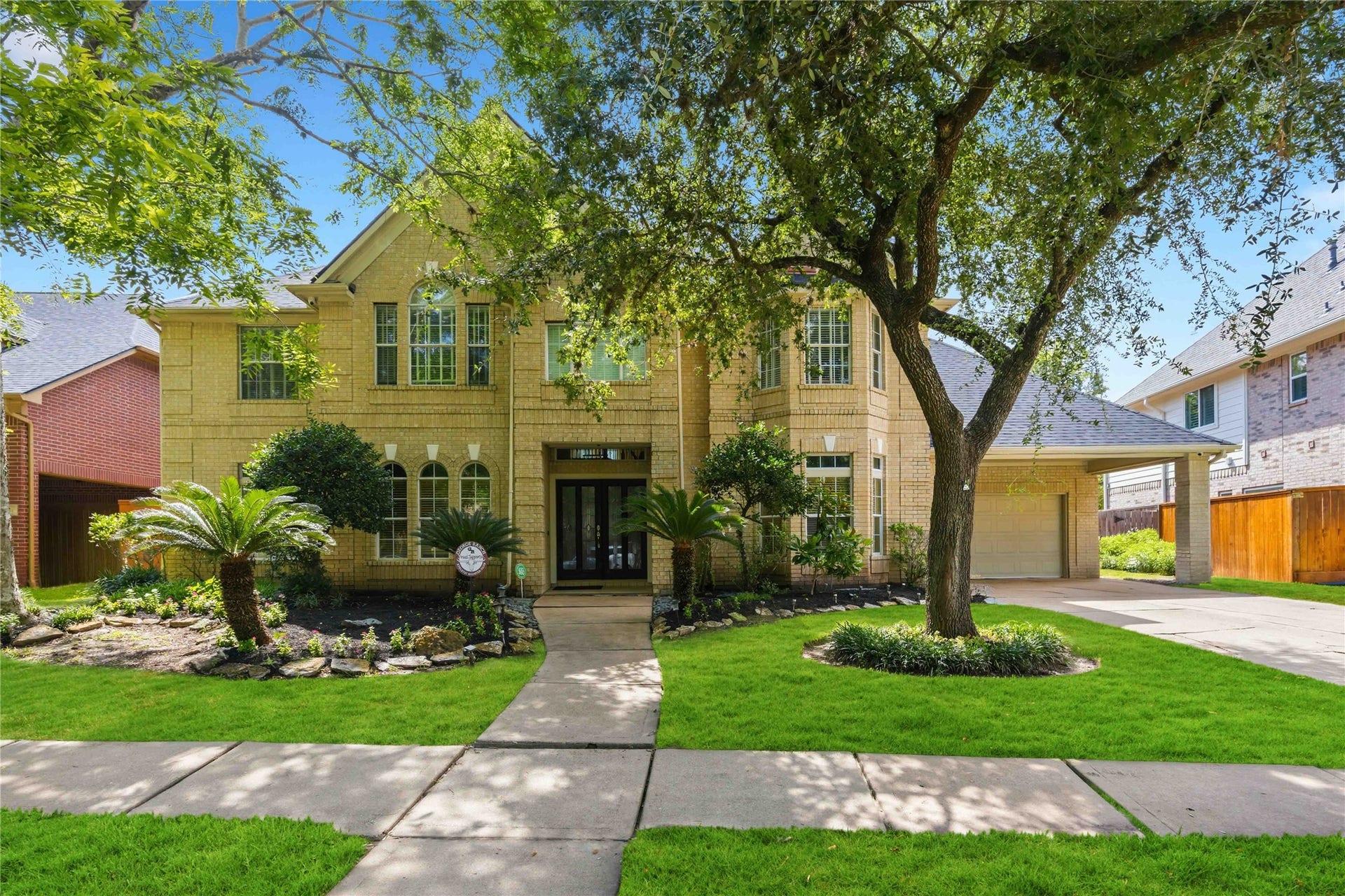 7610 Guinevere Drive, Sugar Land, TX 77479 A striking brick exterior with elegant arched windows, an attached garage port, and a manicured lawn creates a timeless first impression and a picture-perfect welcome home.