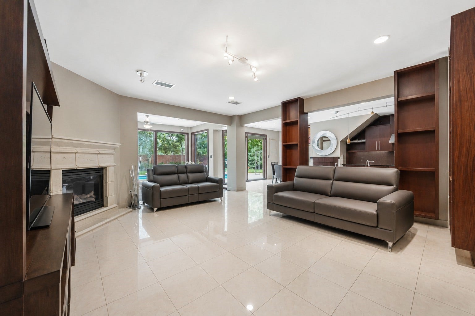 7610 Guinevere Drive, Sugar Land, TX 77479 Large glass sliding doors frame views of the backyard pool, effortlessly connecting the open-concept living area to the outdoor spaces.
