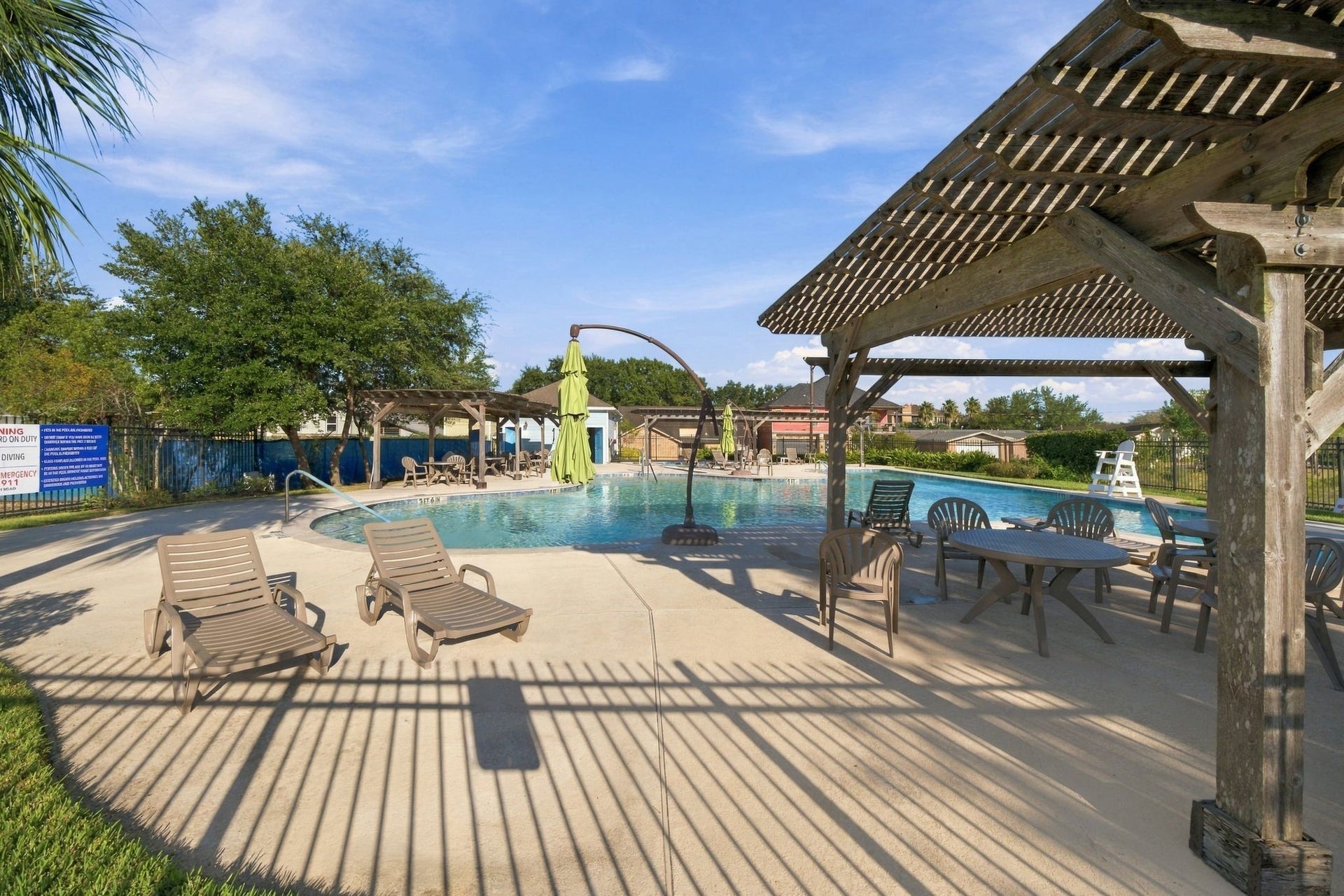 10 Harbor Lane, Kemah, TX 77565 The neighborhood has inviting pool area, featuring ample lounging space and a charming pergola for shaded relaxation.