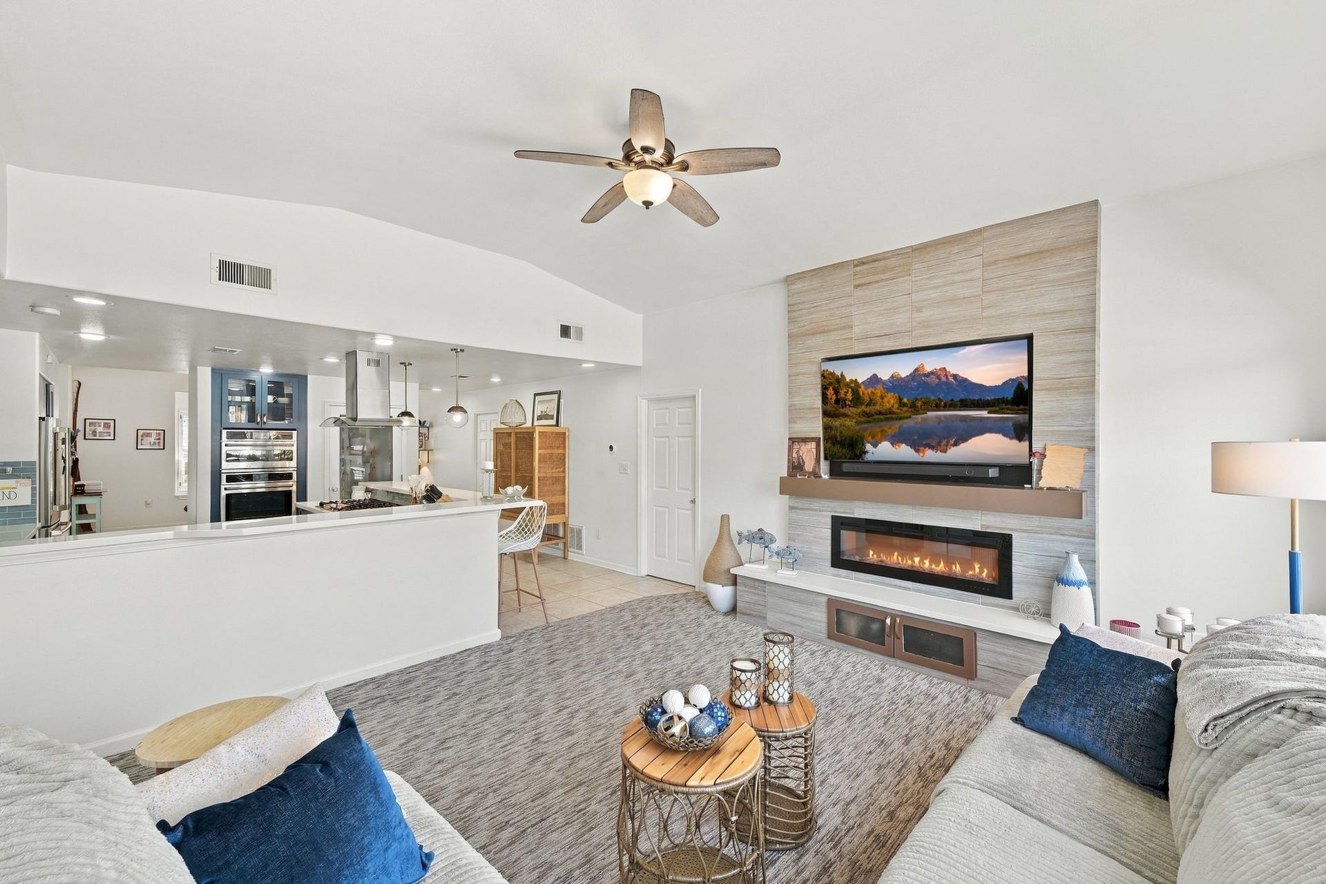 10 Harbor Lane, Kemah, TX 77565 Spacious living area featuring a modern open-concept design, with a cozy electric fireplace and a wall-mounted TV.