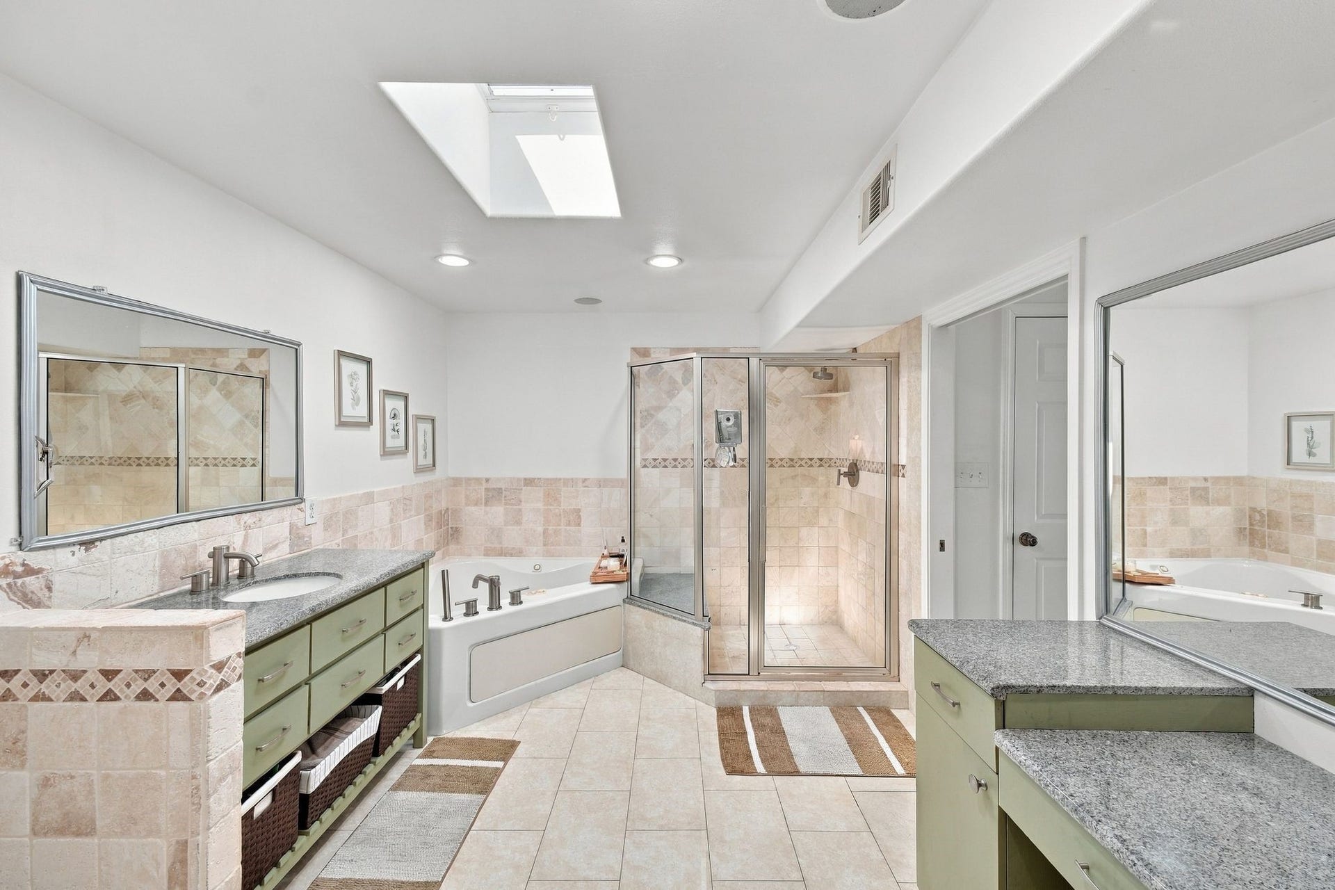 10 Harbor Lane, Kemah, TX 77565 Spacious bathroom featuring a luxurious soaking tub, glass-enclosed shower, dual sinks with granite countertops, and vanity.