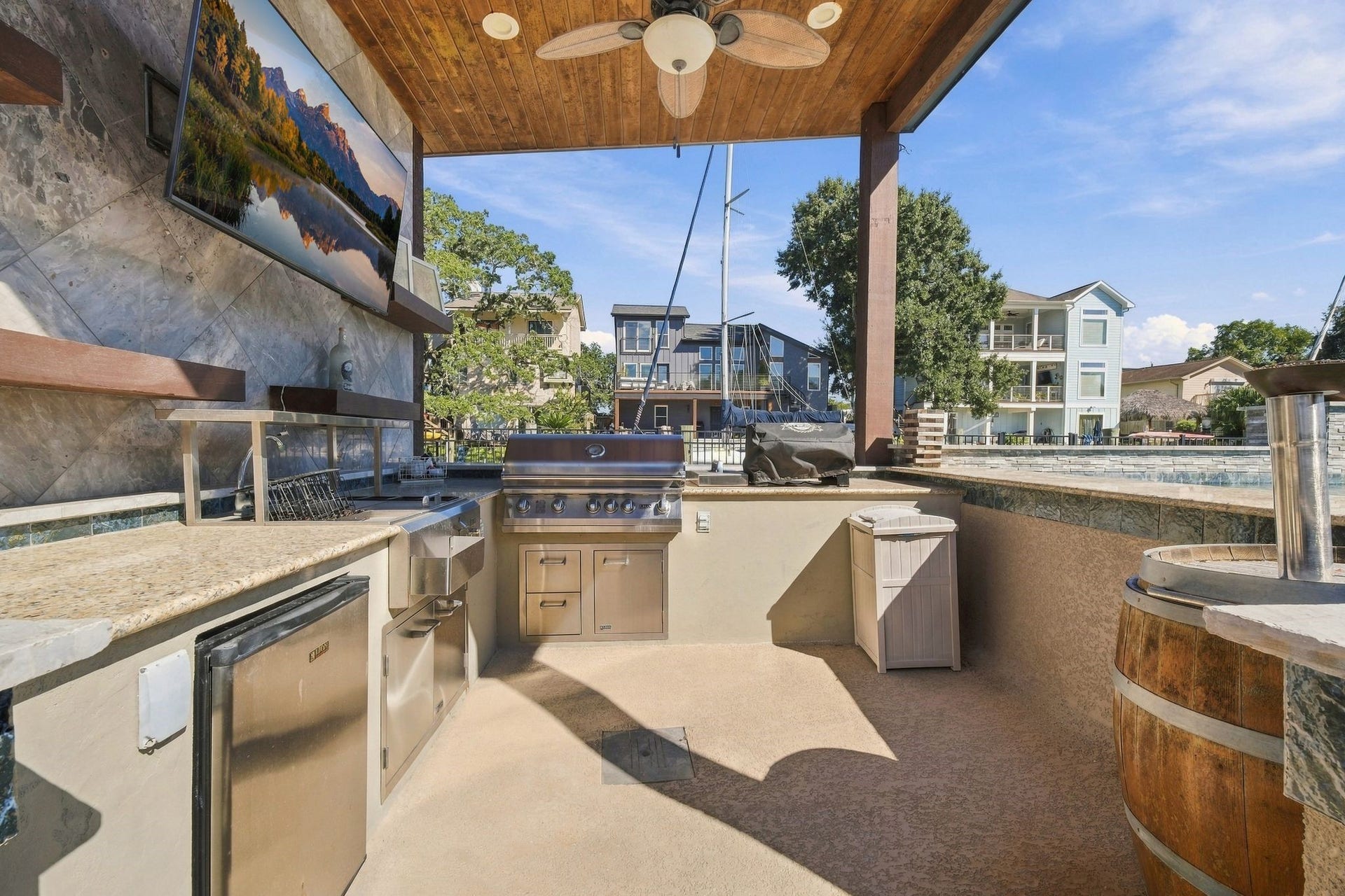 10 Harbor Lane, Kemah, TX 77565 Experience outdoor living at its finest with this stylish outdoor kitchen, featuring sleek stainless steel appliances, a built-in grill, a mounted TV, and a swim up bar.