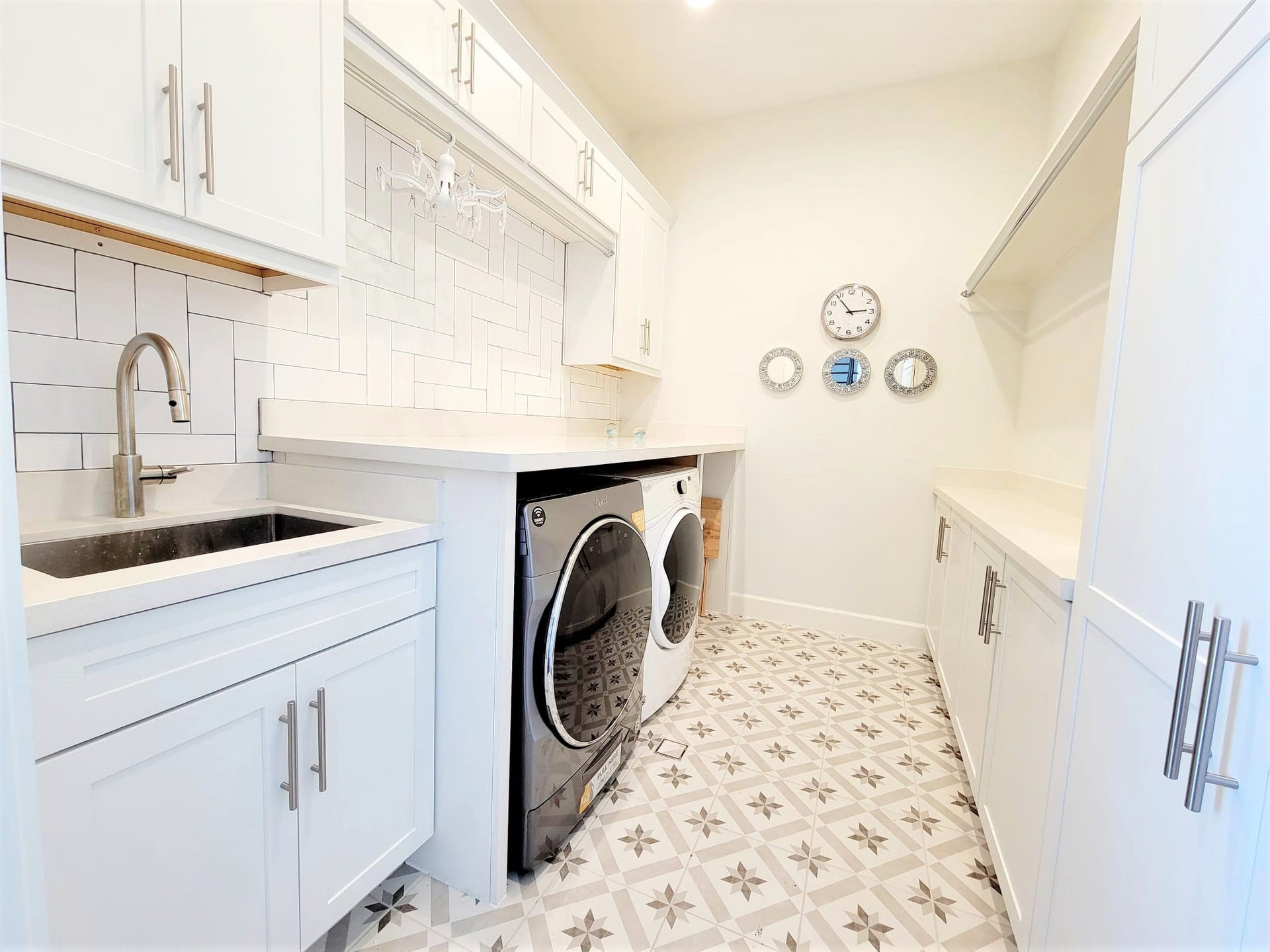 Large Laundry Room with auto soap refill washing machine, wifi capable. Enjoy extra space for folding station, storage and a deep s.s. sink!