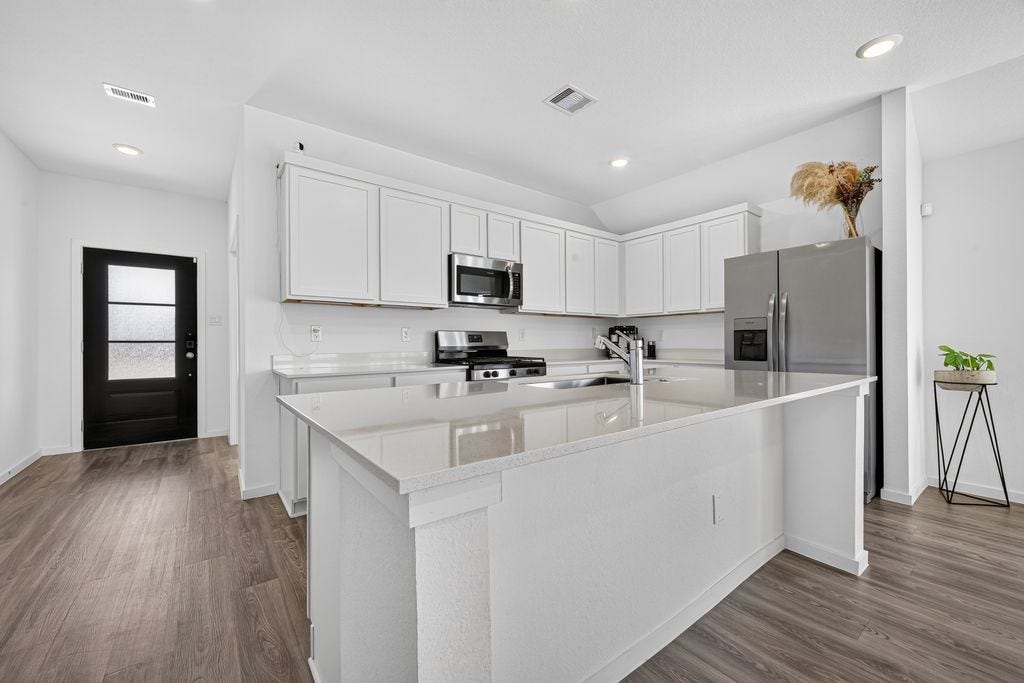 5438 Still Meadow Lane, Richmond, TX 77469 Open-Concept Chefs Kitchen: Designed for seamless living and effortless entertaining, this modern kitchen opens directly into the family room. Features an expansive center island perfect for prep work, breakfast dining, or gathering with guests, alongside abundant cabinetry and generous countertop space. (Spacious pantry located adjacent, not pictured).