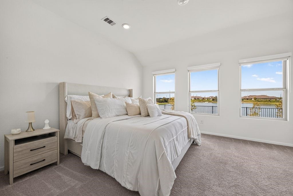 5438 Still Meadow Lane, Richmond, TX 77469 Peaceful Primary Sanctuary: A spacious main retreat positioned to capture soothing, uninterrupted views of the backyard and tranquil water.