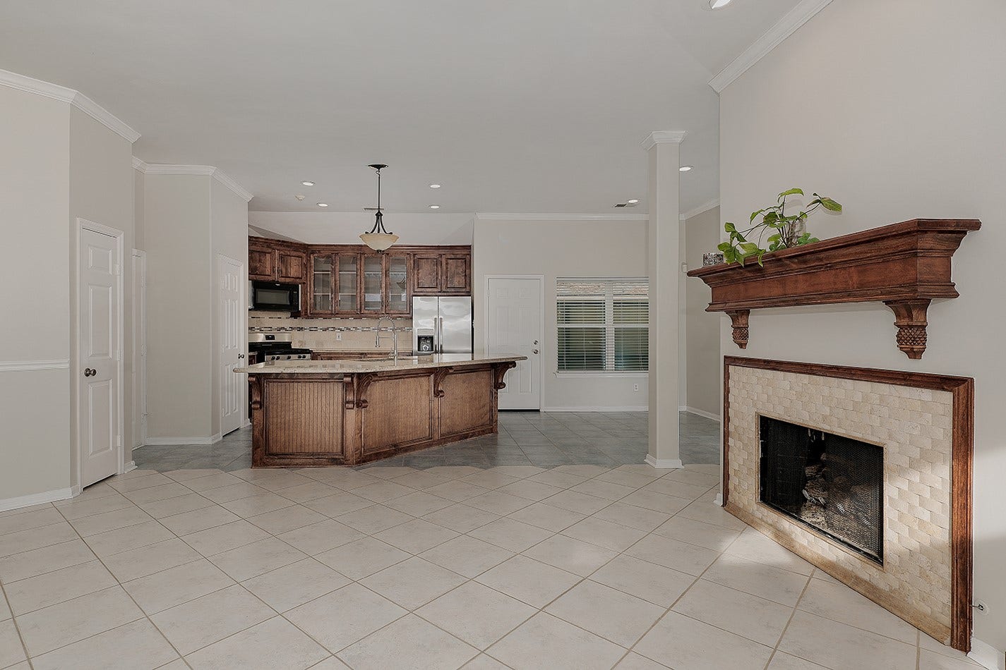 34 Cypress Bayou Court, The Woodlands, TX 77382 View from the family room into the kitchen and dining. Neutral tile flooring throughout enhances the bright and airy feel.