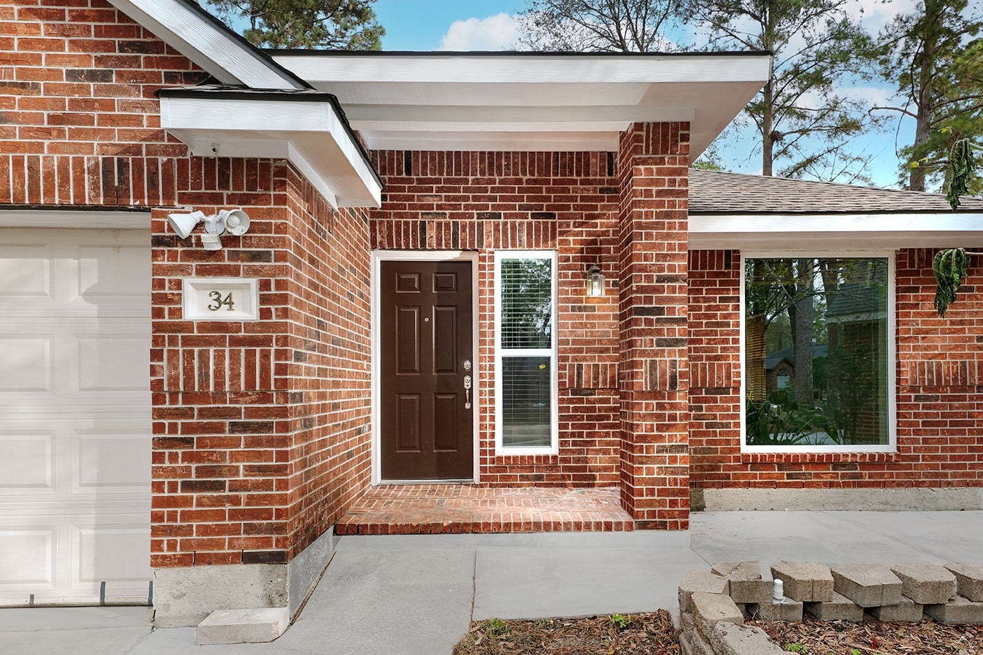 34 Cypress Bayou Court, The Woodlands, TX 77382 Brick exterior with large windows, offering plenty of natural light.