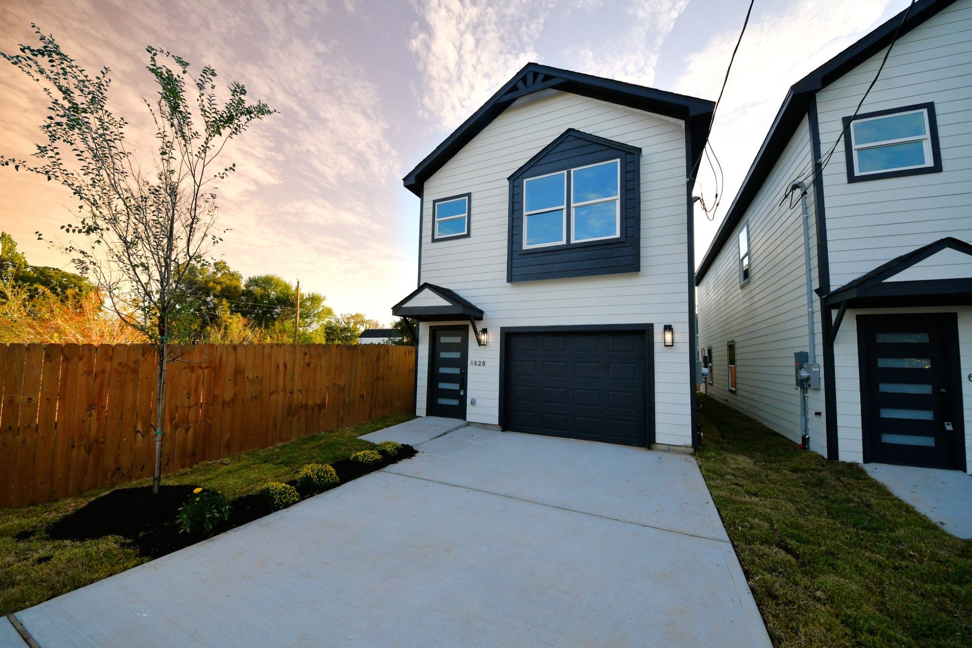 6628 Nielan Street, Houston, TX 77028 The home's modern farmhouse-inspired exterior combines cement board siding, stone accents, dark trim, and a welcoming covered entry. A private driveway leads to the attached 1-car garage.