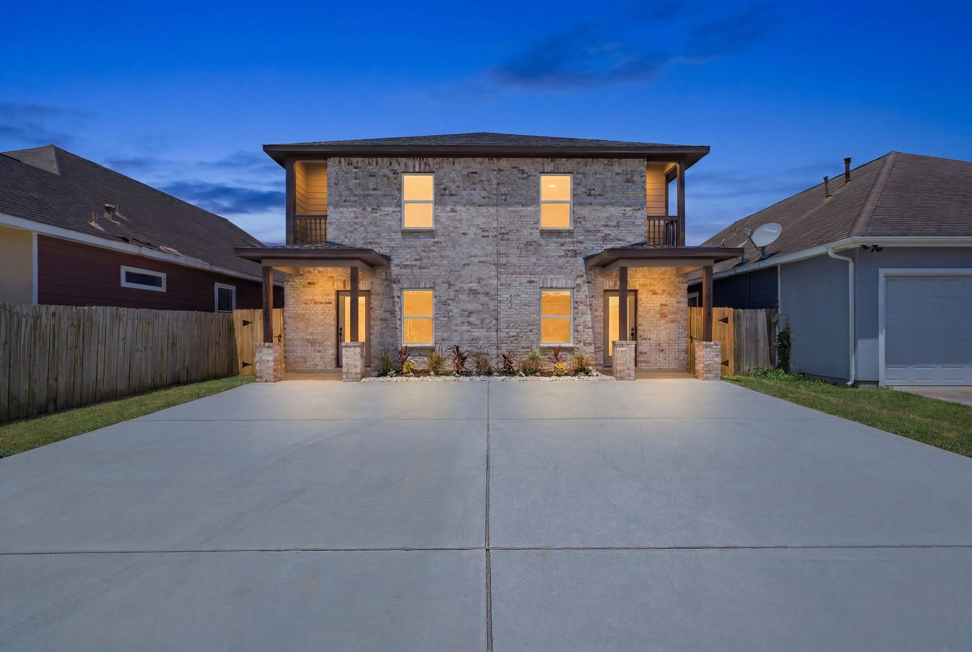 Twilight exterior highlights the duplex's modern design, private entrances and expansive parking.