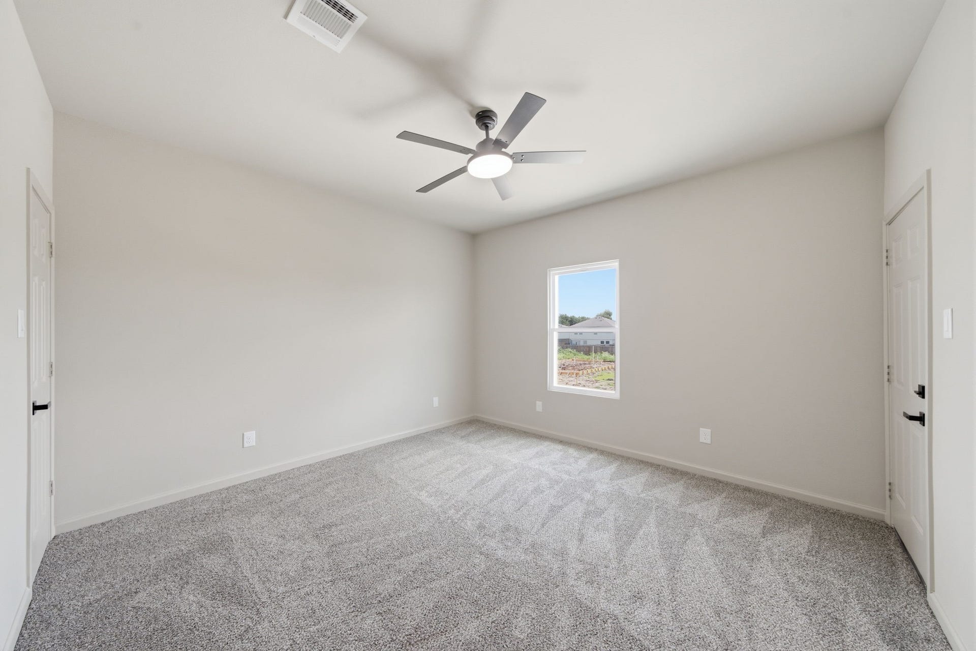 One of two upstairs secondary bedrooms, featuring high ceilings, soft carpeting and abundant natural light.