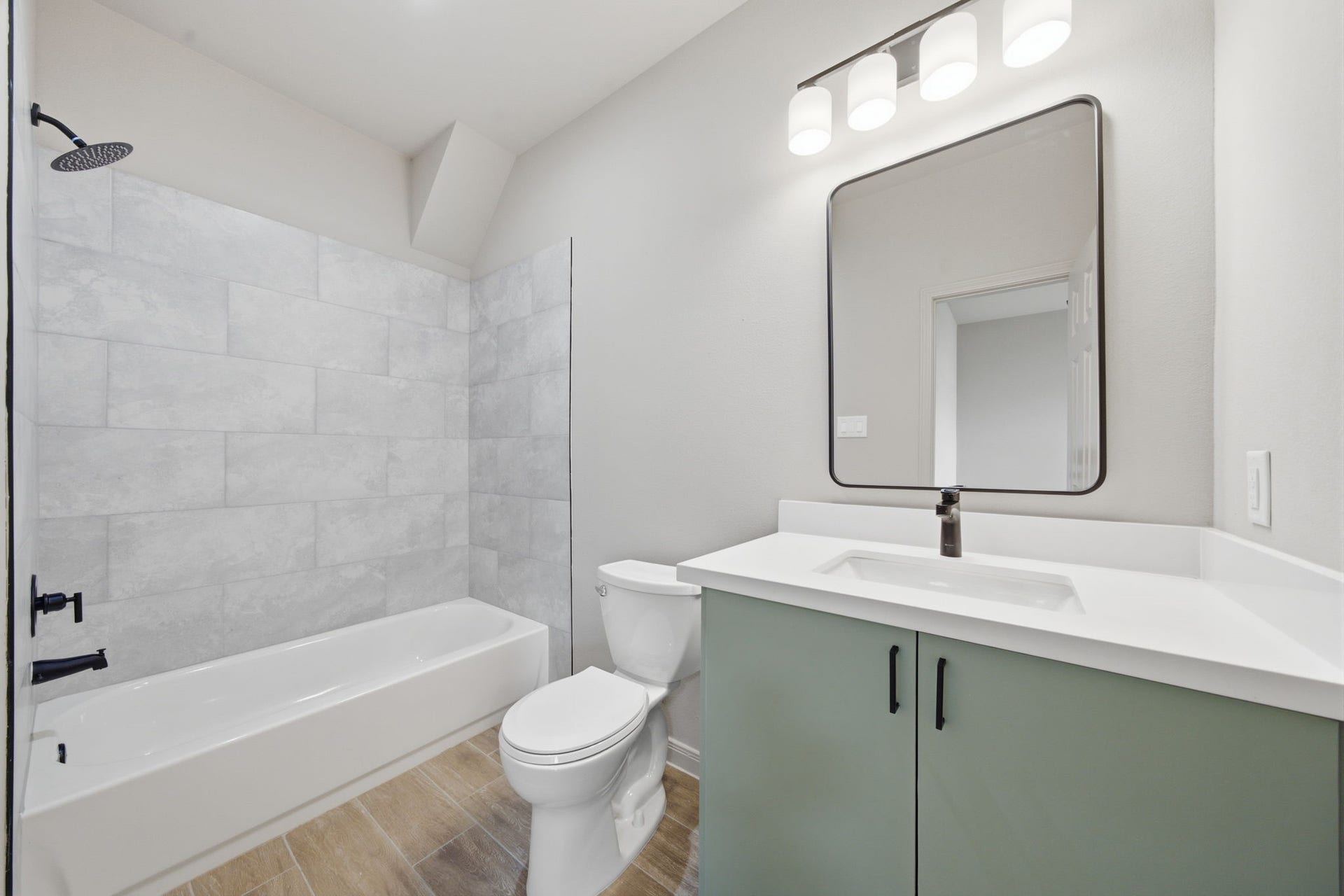 Private primary bath features a quartz-topped vanity, modern black fixtures and full tub/shower combination.