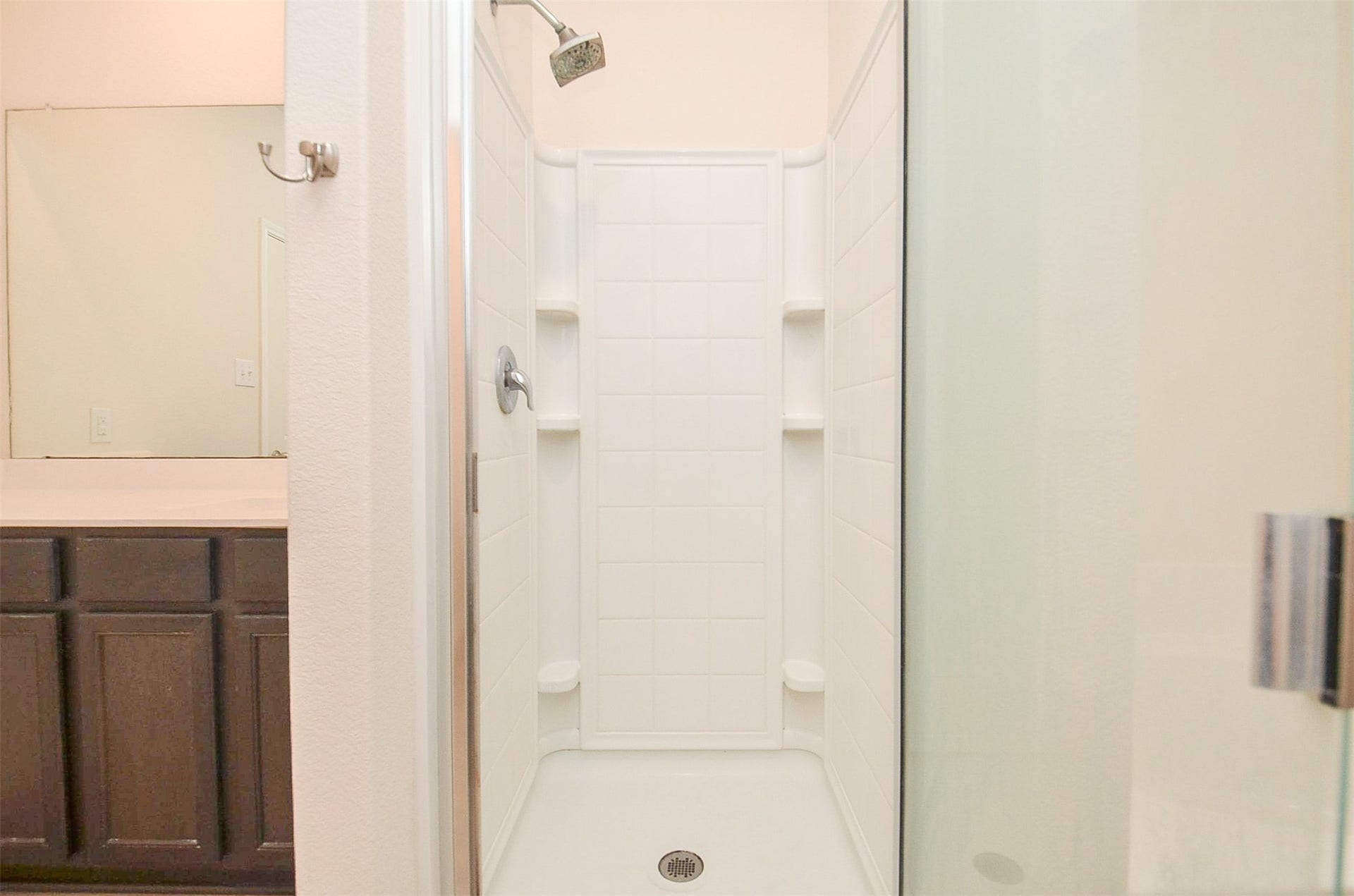 Separate Tiled Shower with Glass Enclosure and Soak Tub.