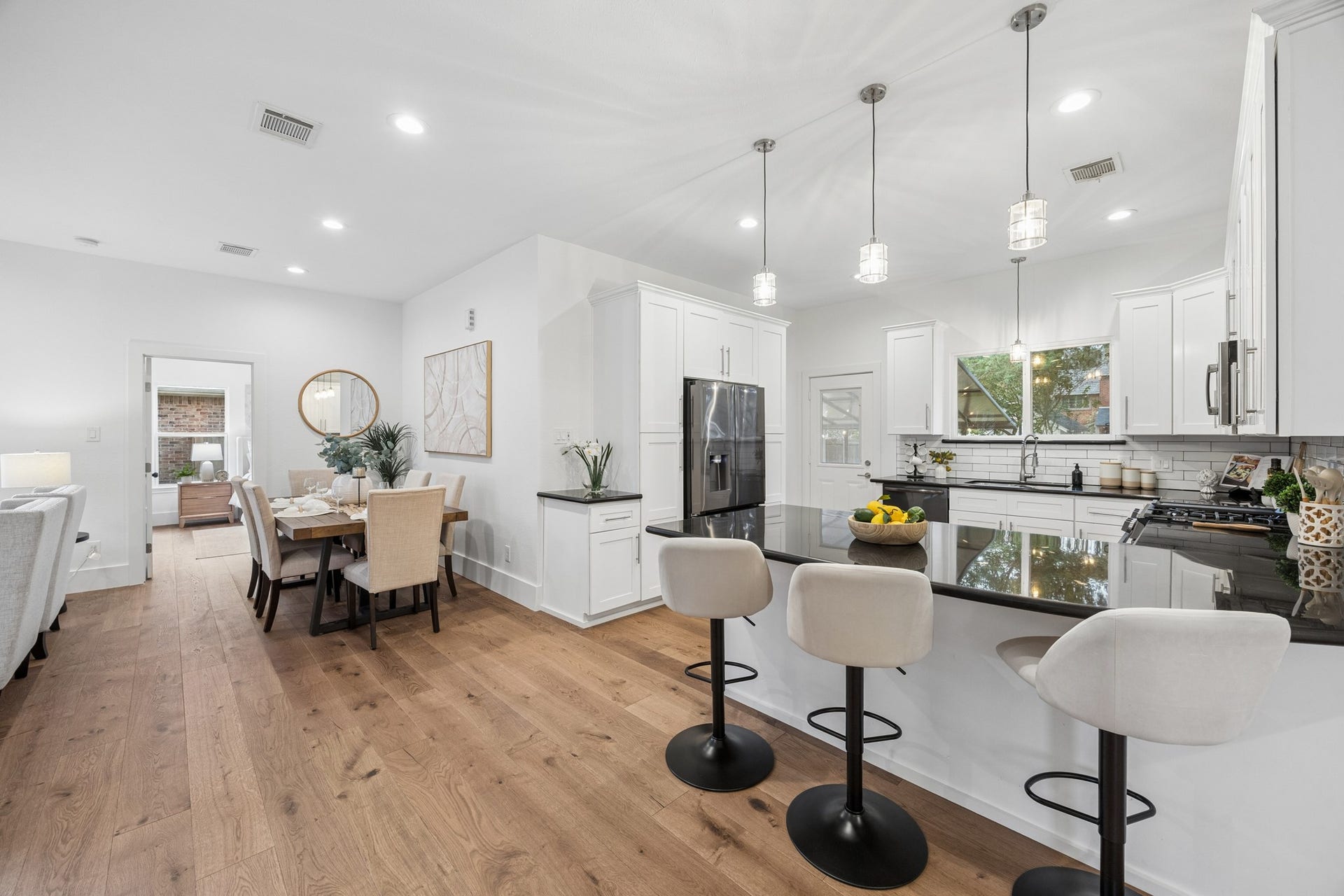 711 4th Street, Sealy, TX 77474 Spacious kitchen with sleek black countertops, elegant pendant lighting, and ample seating at the island. Adjoining dining area perfect for entertaining.