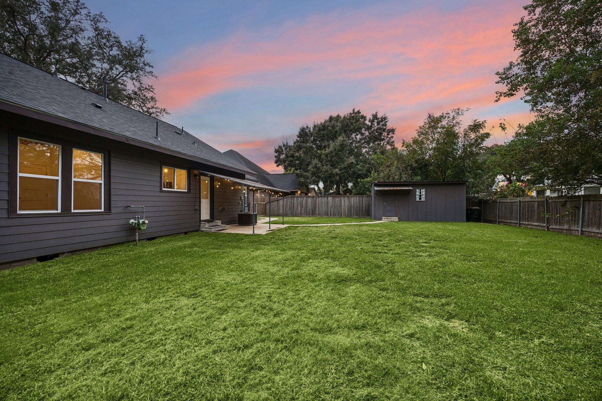 711 4th Street, Sealy, TX 77474 Spacious backyard with a cozy patio, perfect for outdoor relaxation and gatherings.
