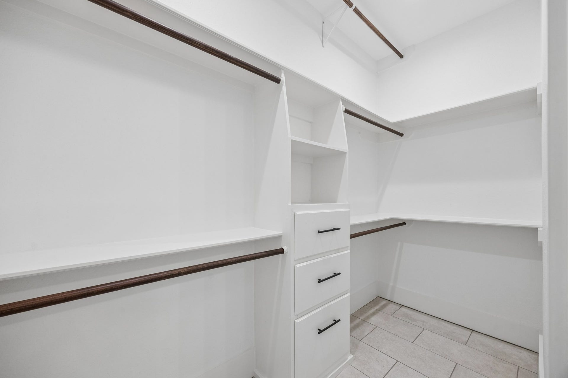 711 4th Street, Sealy, TX 77474 Spacious walk-in closet with ample shelving, hanging space, and built-in drawers for organized storage.