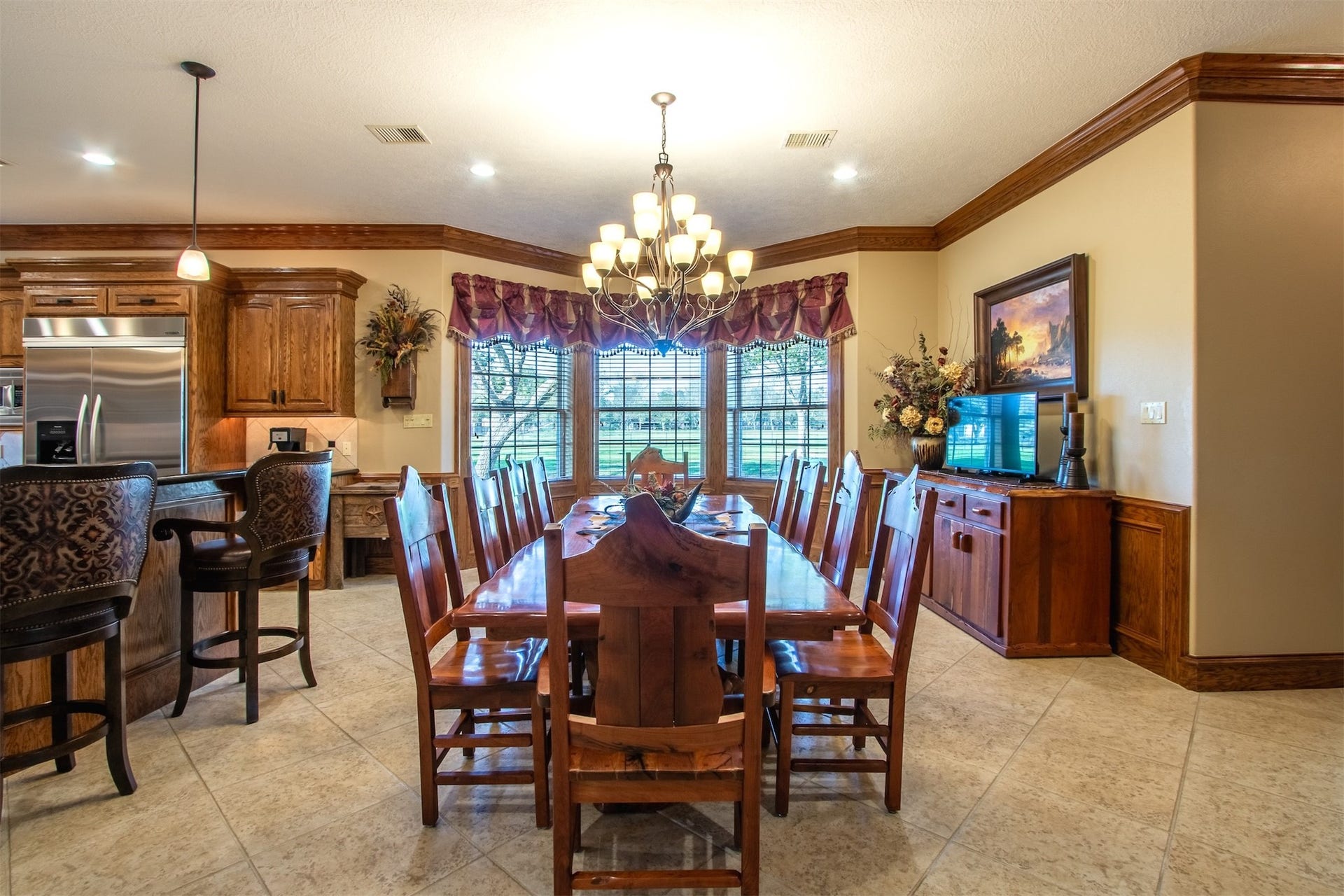 3150 Holmes Road Road, Richmond, TX 77406 Elegant dining area with a spacious table, warm wood accents, and a stylish chandelier, perfect for hosting gatherings.