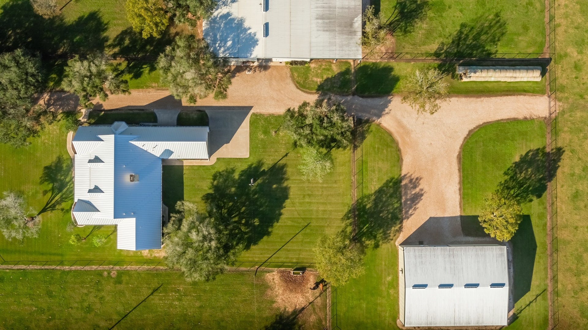 3150 Holmes Road Road, Richmond, TX 77406 Expansive property layout showcasing lush greenery, spacious grounds, and multiple well-maintained structures.