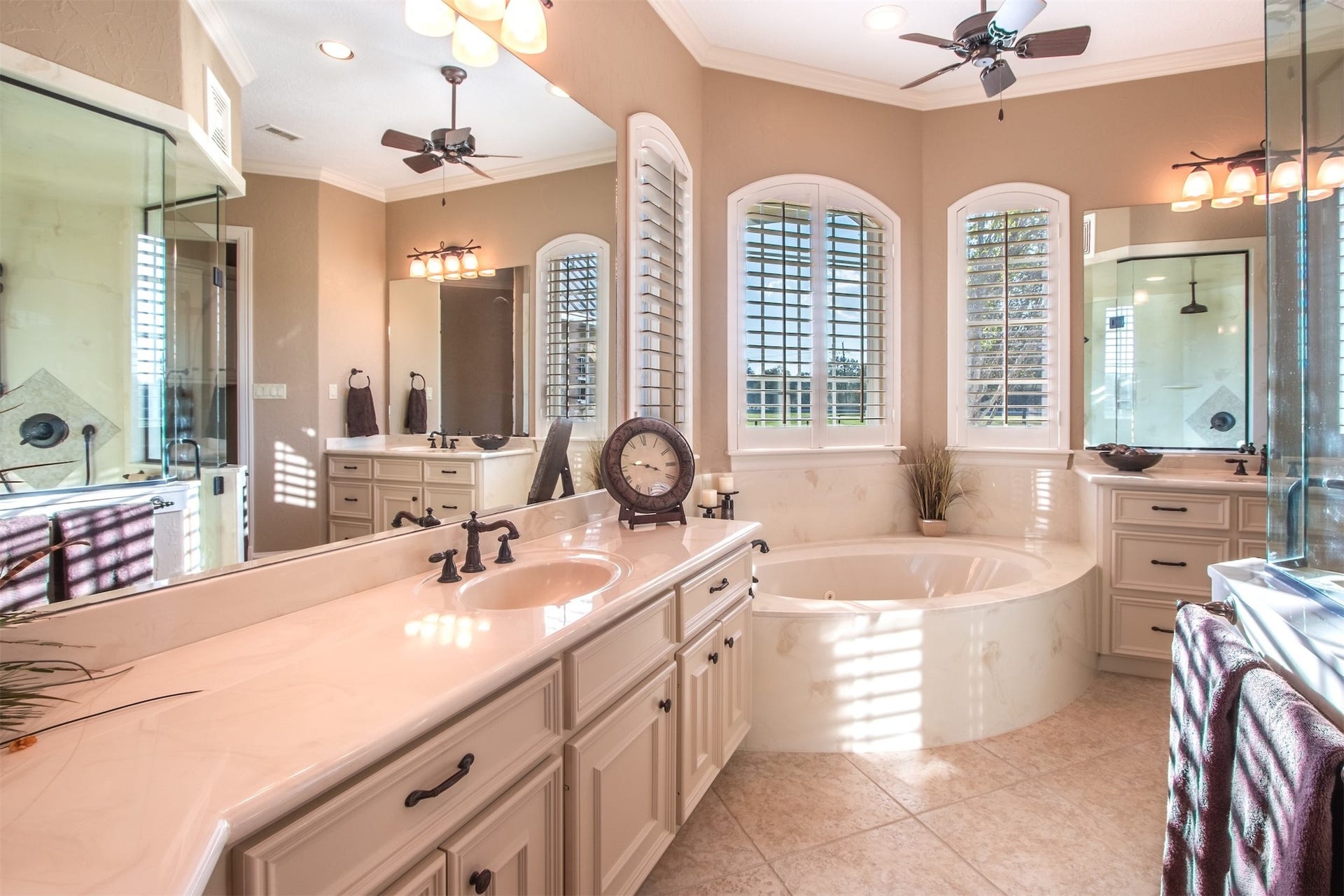 3150 Holmes Road Road, Richmond, TX 77406 Luxurious primary bath featuring dual vanities, elegant fixtures, a relaxing soaking tub, and a spacious glass-enclosed shower.