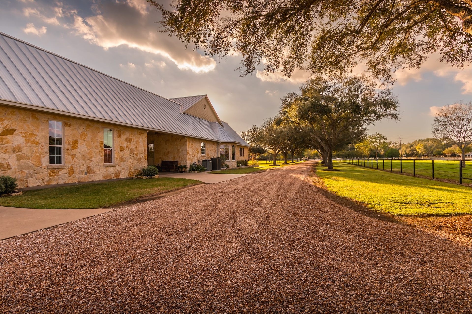 3150 Holmes Road Road, Richmond, TX 77406 Experience serene country living in this charming stone home, nestled along a picturesque tree-lined driveway with expansive green views.