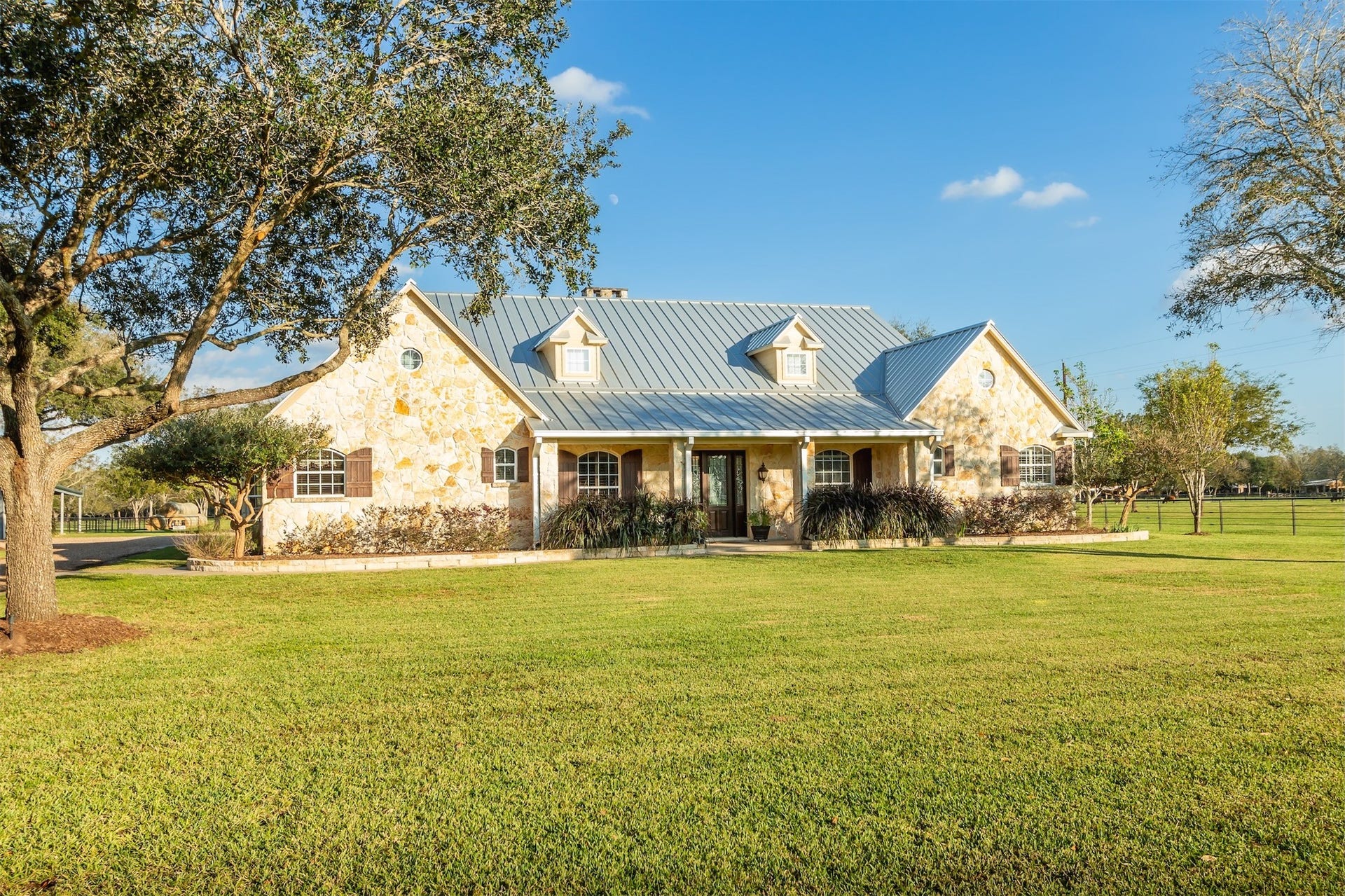 3150 Holmes Road Road, Richmond, TX 77406 Charming Austin limestone home with a welcoming front porch and spacious yard, offering a perfect blend of rustic elegance and modern comfort.
