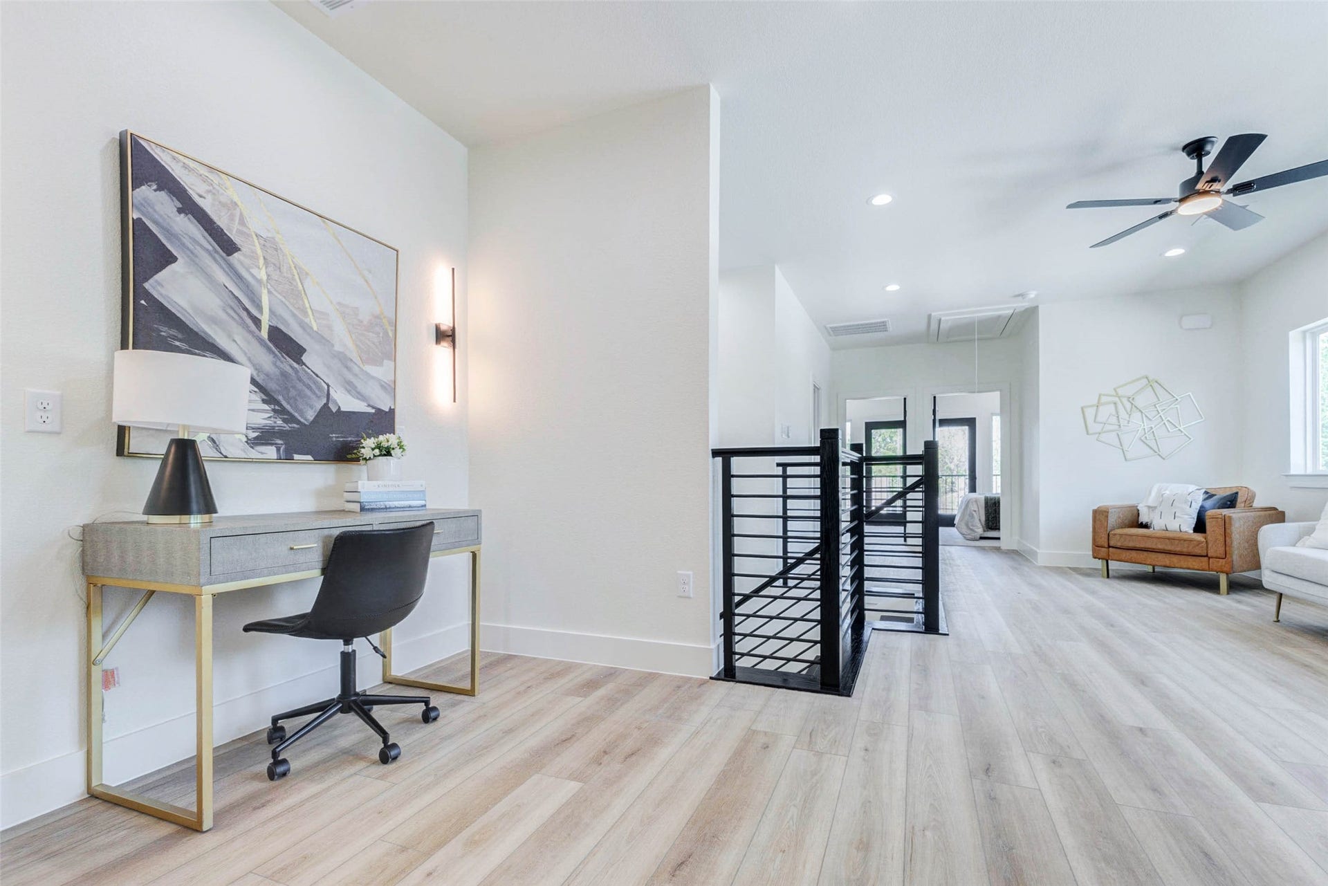 Versatile wide-plank flooring extends throughout the upstairs landing, which includes dedicated wall space for a workstation or console.