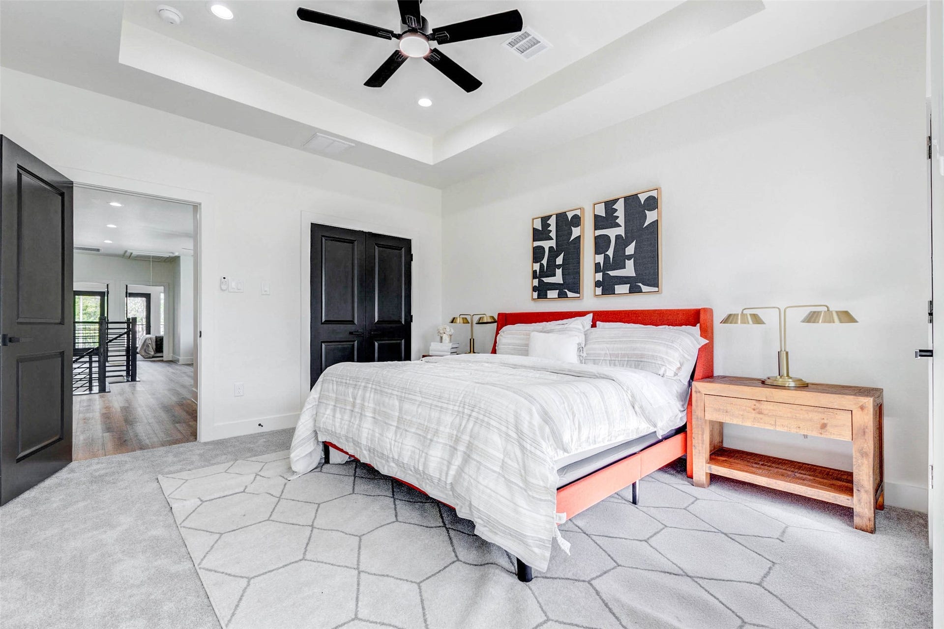 Clean lines and a neutral palette define the bedroom, which includes a modern ceiling fan and large walk-in closet.
