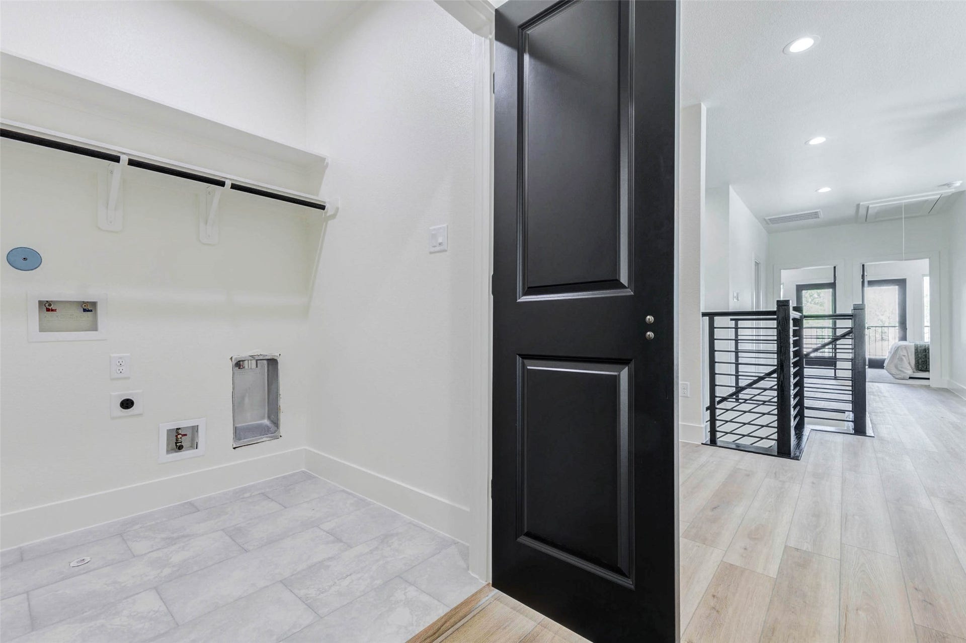 A dedicated laundry room provides convenient tile flooring, built-in shelving, and pre-installed hookups for a washer and dryer.