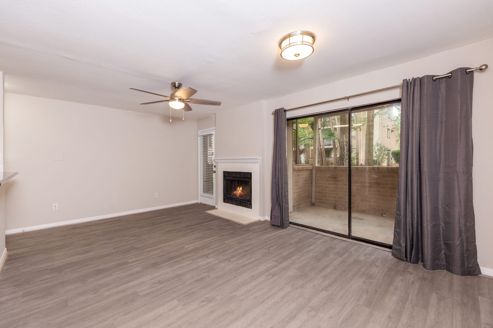 The large windows overlook the back patio, which in turn offers a view of the back greenspace.