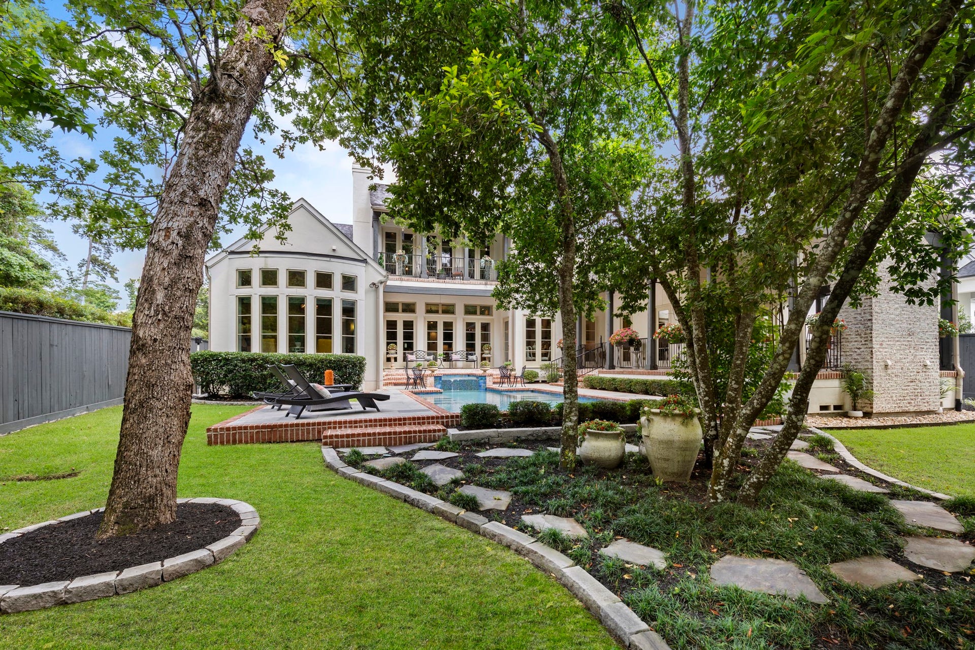 79 Simon Lake Lane, The Woodlands, TX 77381 Beautifully landscaped backyard with winding pathways and mature trees.