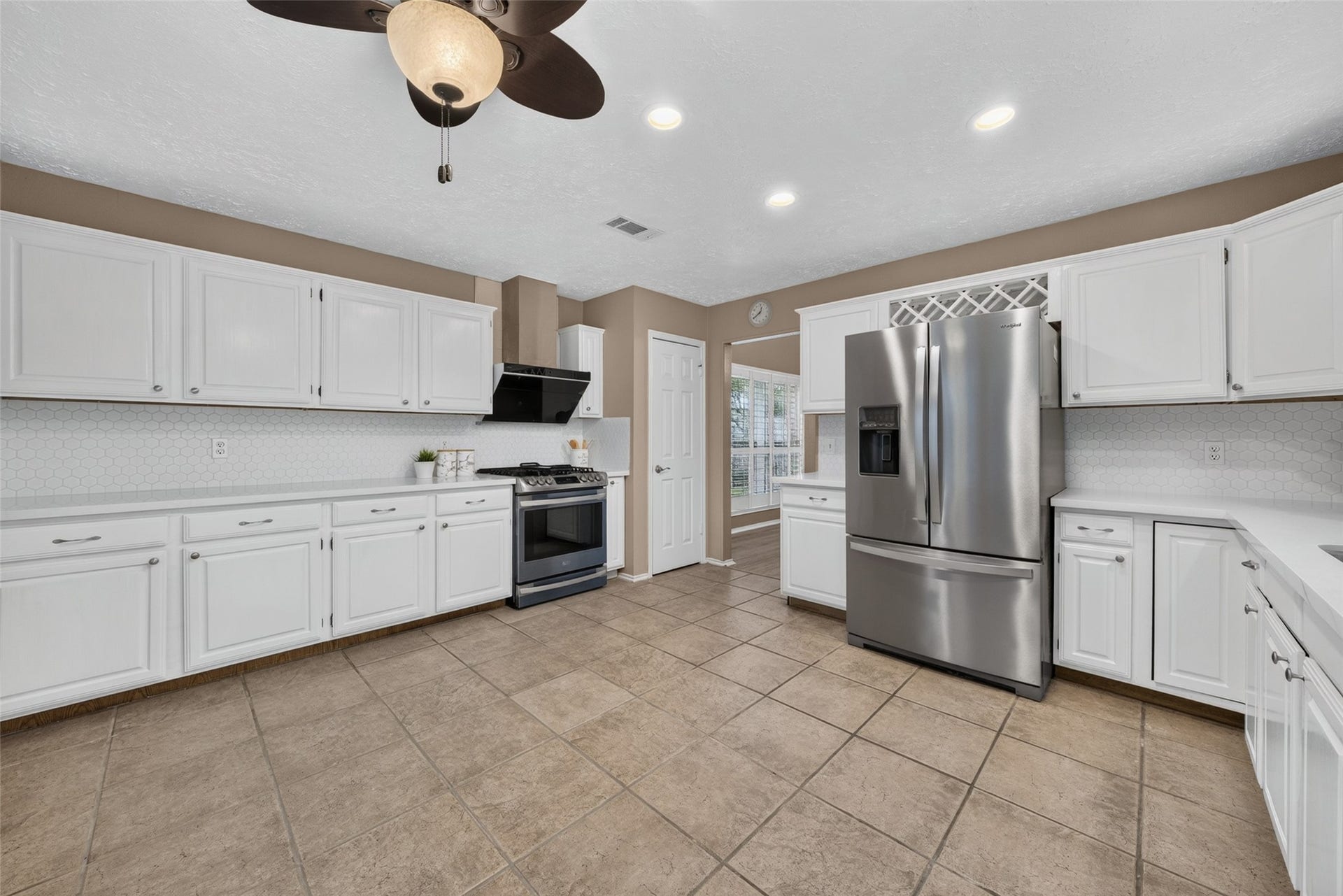 3507 Santa Rosa Lane, Sugar Land, TX 77478 The bright, open kitchen boasts pristine white cabinetry, stainless steel appliances, and a custom built-in wine rack.