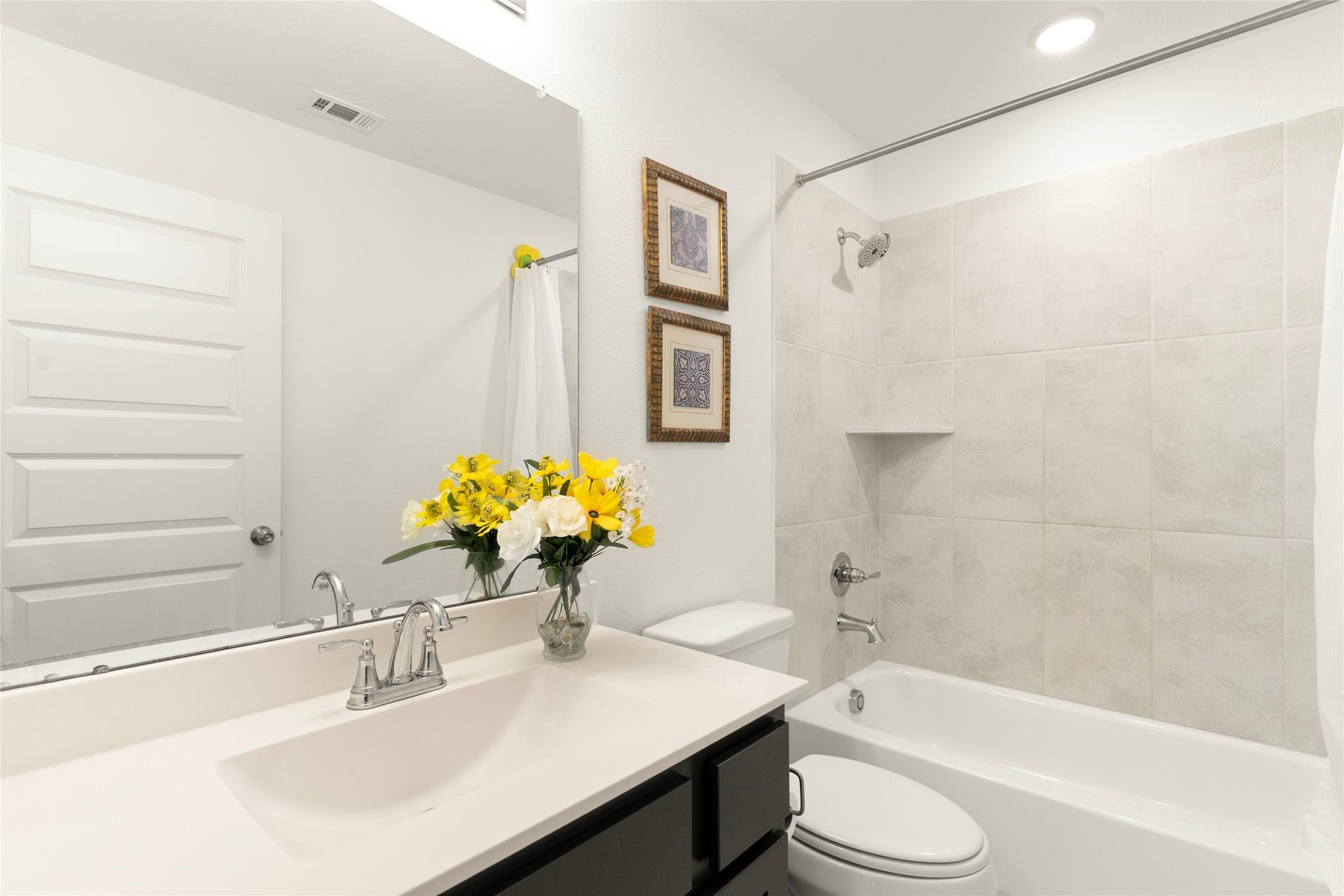 11111 Zinnias Court, Cypress, TX 77433 A beautifully finished secondary bathroom offers a generous vanity, decorative touches, and a tub-and-shower combination.