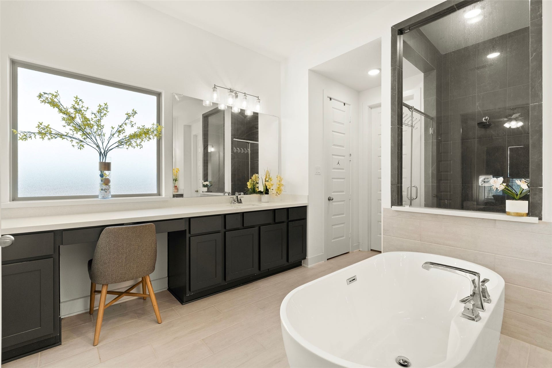 11111 Zinnias Court, Cypress, TX 77433 Dual vanity areas, abundant cabinetry, and a freestanding tub make this primary bathroom both luxurious and practical.