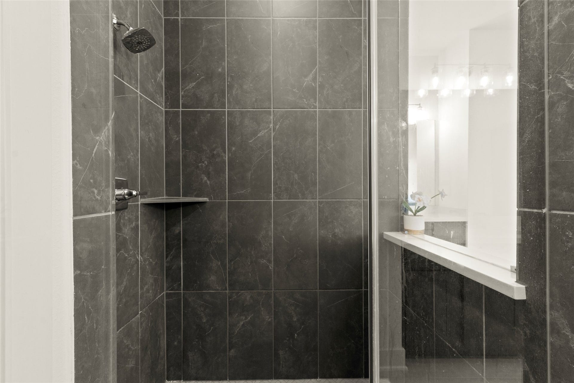 11111 Zinnias Court, Cypress, TX 77433 The spacious walk-in shower features striking dark tile, glass enclosure, and beautiful contemporary finishes.