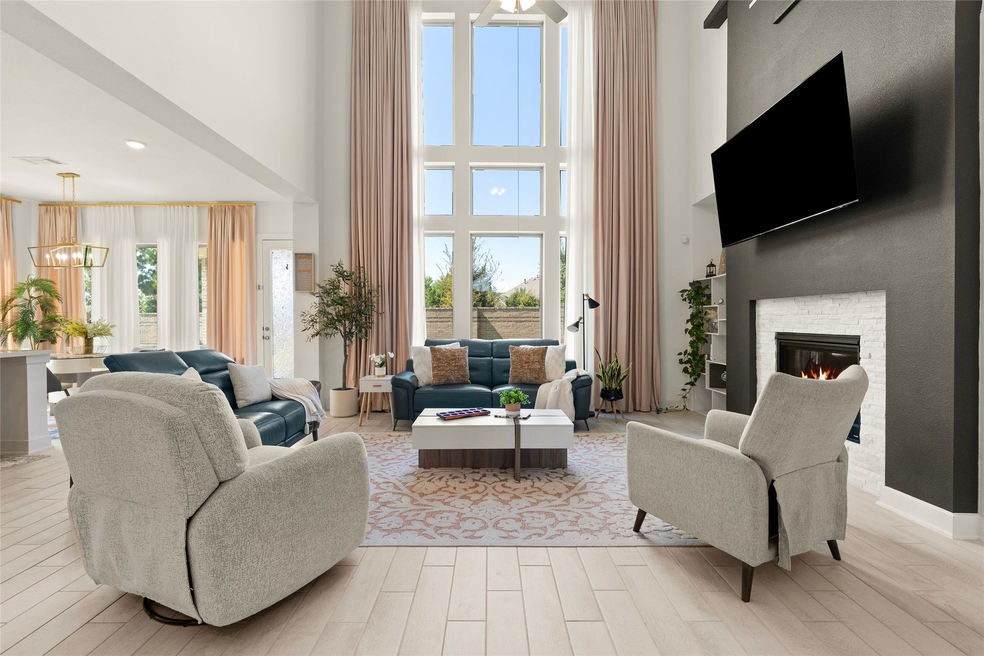11111 Zinnias Court, Cypress, TX 77433 Soaring two-story windows fill this breathtaking living room with natural light, creating a dramatic backdrop for the fireplace and beautiful open layout.