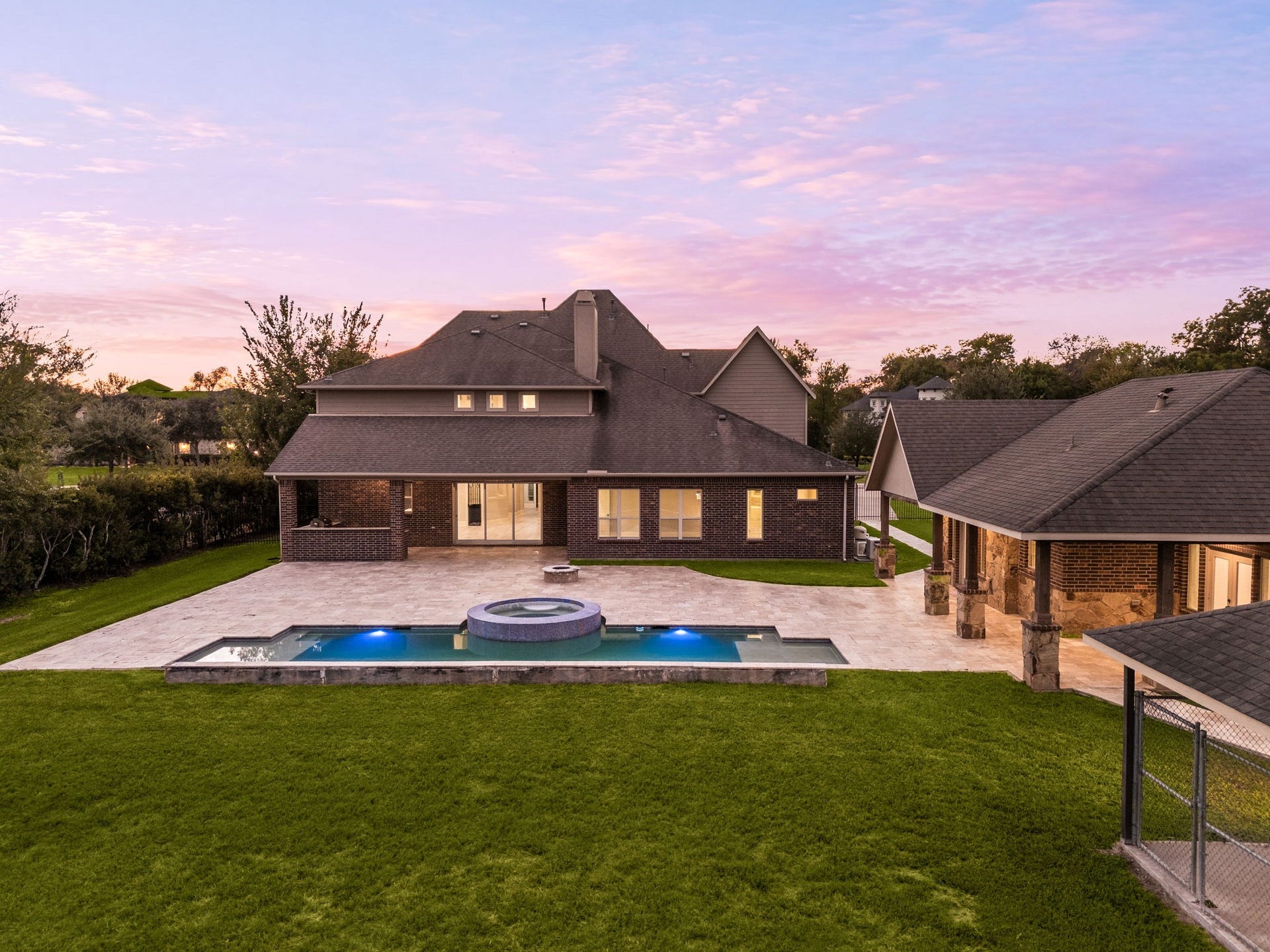 5127 Beekman Drive, Missouri City, TX 77459 As the sun sets, the backyard oasis comes to life with an in-ground pool, spa, and expansive covered patio, with the detached casita just steps away.